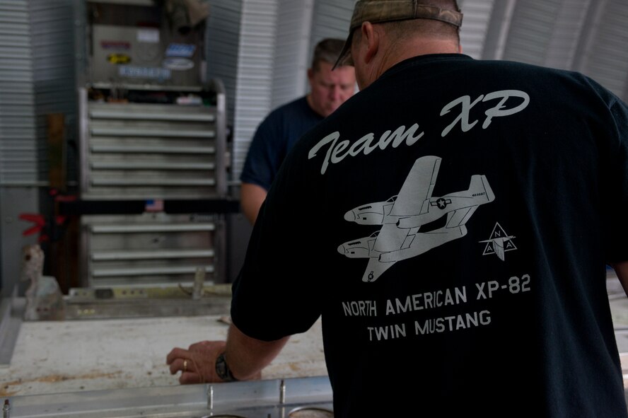 A member of the B-25 Group sets down an aircraft part on a work table in a hangar in Douglas, Ga., Oct. 18, 2011. Tom Reilly, owner of the B-25 Group, hired a small group of aircraft mechanics to help with the restoration of an XP-82 Twin Mustang. (U.S. Air Force photo by Airman 1st Class Jarrod Grammel/Released) 
