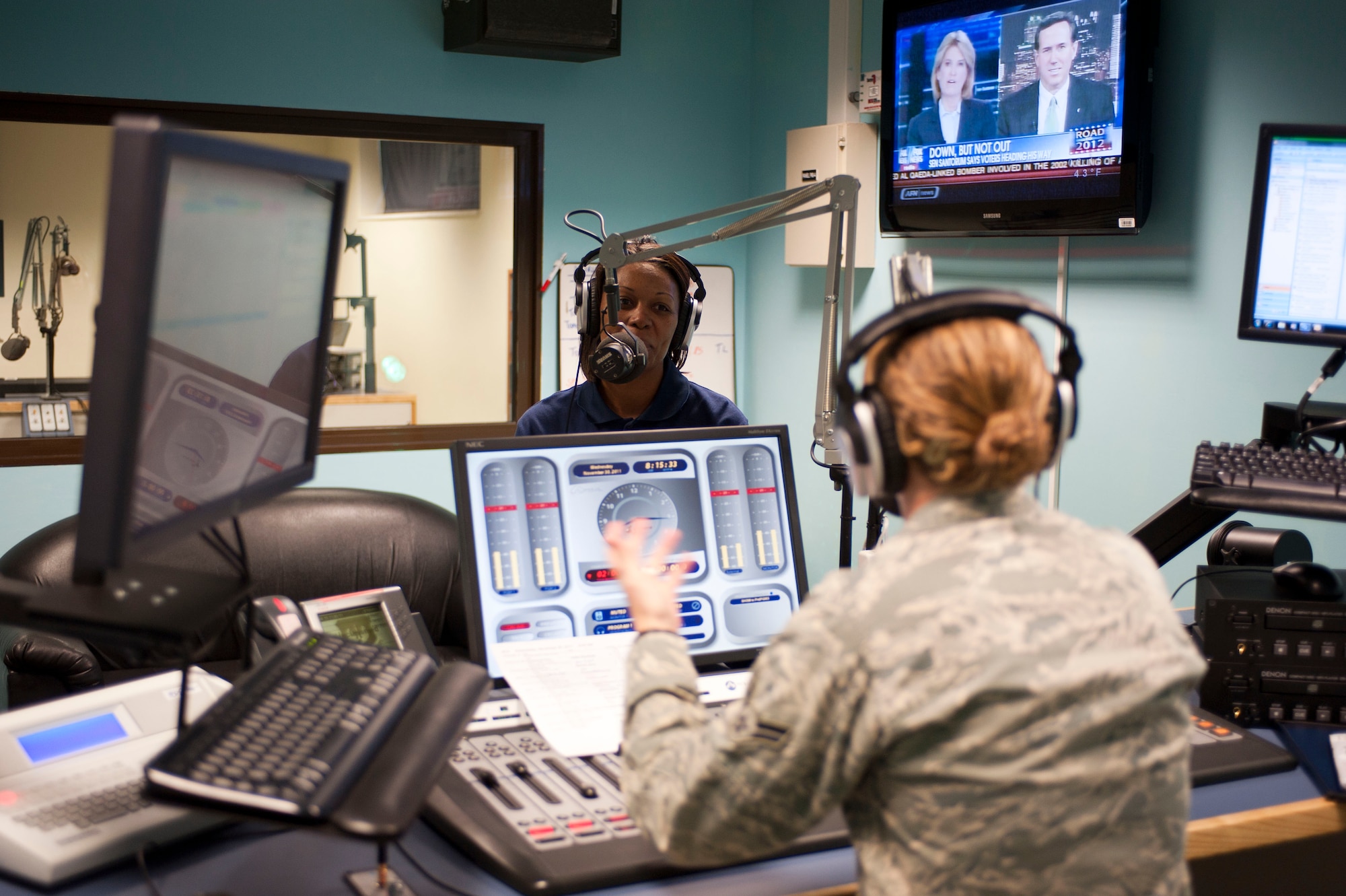 Airman 1st Class Laura Beckley, American Forces Network Incirlik, speaks with radio show guest Master Sgt. Tapika Bryant, 39th Force Support Squadron, during a radio show Nov. 30, 2011, at Incirlik Air Base, Turkey. Bryant was on the show to give information about the fitness assessment cell and exercising in cold weather. (U.S. Air Force photo by Senior Airman Clayton Lenhardt/Released)