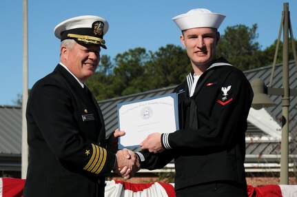 Petty Officer 3rd Class Raymond Huber receives the Class Honorman award from Capt. Thomas Bailey during the Naval Nuclear Power Training Command graduation ceremony for class 1105 at Joint Base Charleston - Weapons Station Dec. 2.  The class Honorman is the Sailor with the highest grade point average for the enlisted class. Huber, an Electronics Technician, earned an overall GPA of 3.92. Bailey is the NNPTC commanding officer. (U.S. Navy photo/Petty Officer 2nd Class Brannon Deugan)
