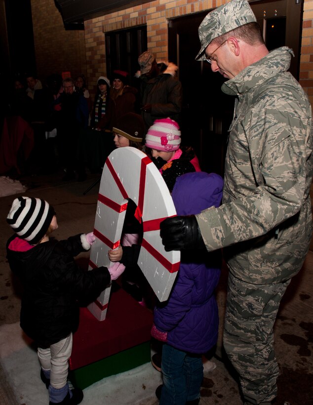 Col. Steven Hiss, 28th Bomb Wing vice commander,  and children of deployed Airmen pull the candy-cane switch to light the Ellsworth Christmas tree during the 28th Bomb Wing Christmas Tree Lighting Ceremony at the Freedom Chapel on Ellsworth Air Force Base, S.D., Dec. 1, 2011. This annual event kicks off the holiday season. (U.S. Air Force photo by Airman 1st Class Kate Thornton/Released)
