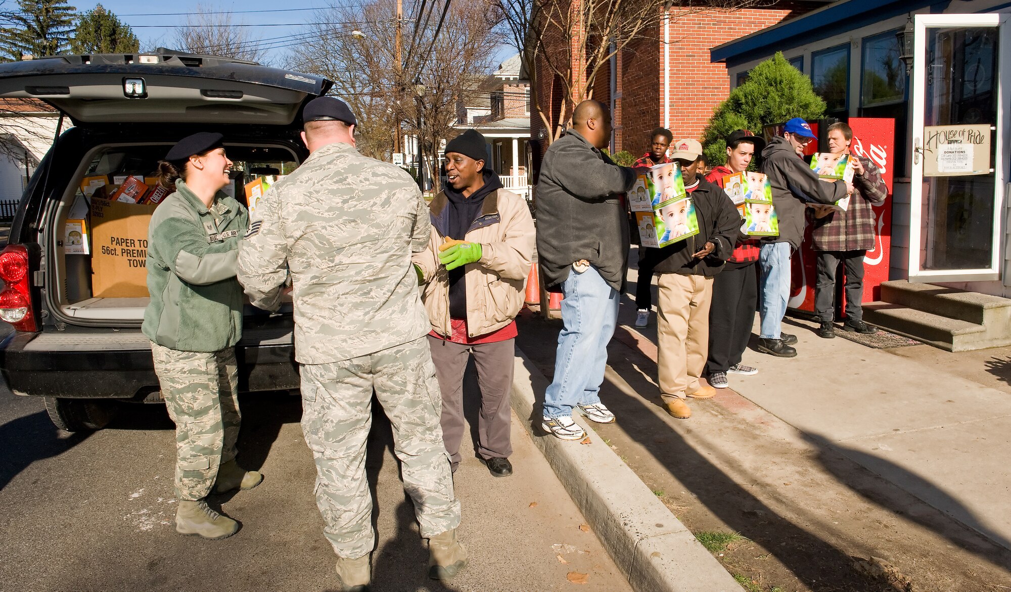 Members of the 436th Security Forces Squadron at Dover Air Force Base, Del., deliver more than 600 non-perishable food items to the House of Pride Dec. 2, 2011. Shelter residents helped them carry the donations inside. (U.S. Air Force photo by Roland Balik)
