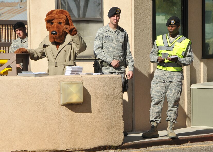 McGruff the Crime Dog and Airmen from the 377 SFS enforce proper seat belt and cell phone use as people depart Kirtland Air Force Base. U.S. Air Force Photo by Todd Berenger.