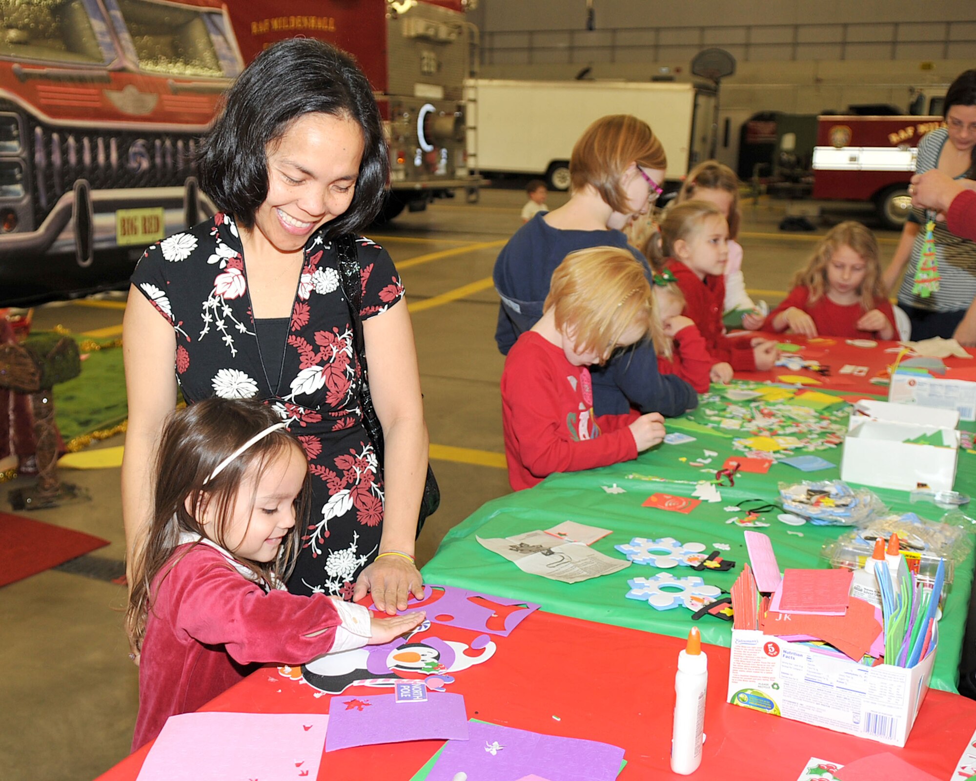 RAF MILDENHALL, England – Senny Stanford assists daughter Evangeline, 4, with an arts and crafts project during the third annual Breakfast with Santa event at the fire department here Dec. 3, 2011. The event offered more than just breakfast - several activity stations were set up including face painting, a story corner, bouncy castles and Christmas-themed arts and crafts projects. Each child was also able to take a photo with Santa Claus and received a gift. (U.S. Air Force photo/Senior Airman Jerilyn Quintanilla)