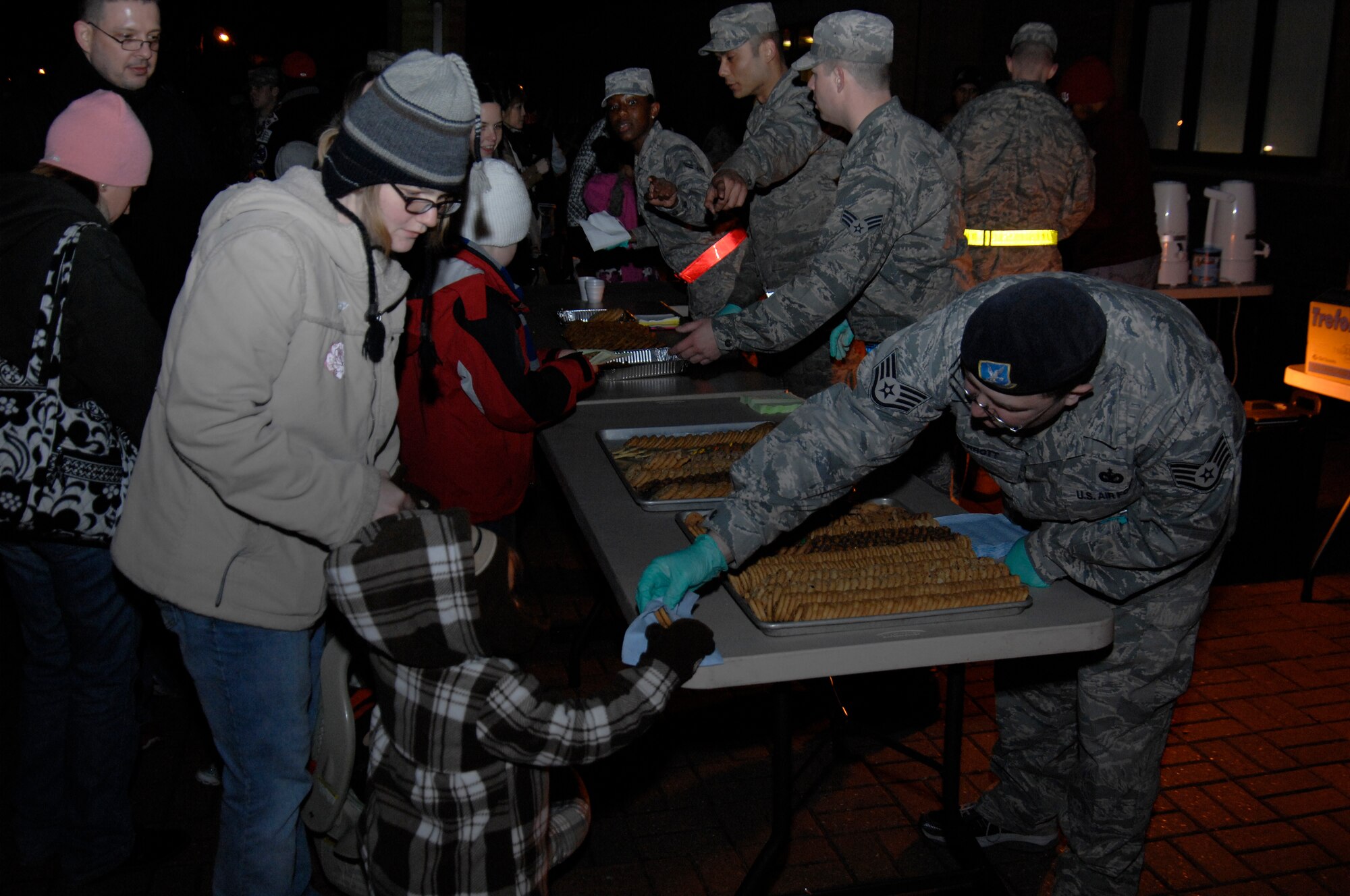 ROYAL AIR FORCE LAKENHEATH, England - Airmen hand out cookies at the 48th Fighter Wing Christmas tree lighting ceremony, Dec. 2, 2011. In addition to the cookies, the event featured caroling and a visit from Santa Claus. (U.S. Air Force photo by Staff Sgt. David Dobrydney)