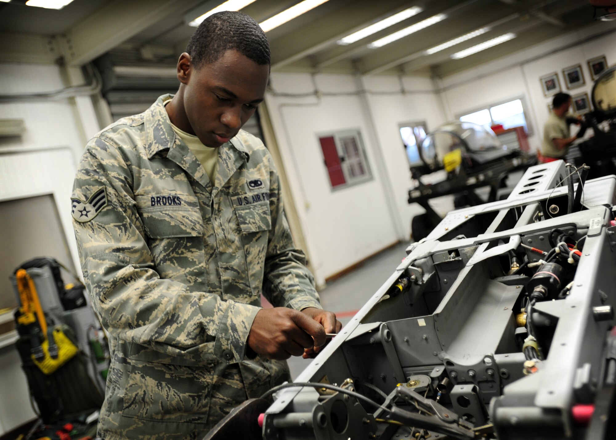 Senior Airman Corey Brooks, 31st Maintenance Squadron aircrew egress systems journeyman, repairs an ejection seat Dec. 5 at Aviano Air Base, Italy.  Aircrew egress systems technicians perform thorough inspections of egress systems, subsystems and components for safety, security and serviceability.  (Staff Sgt. Evelyn Chavez)