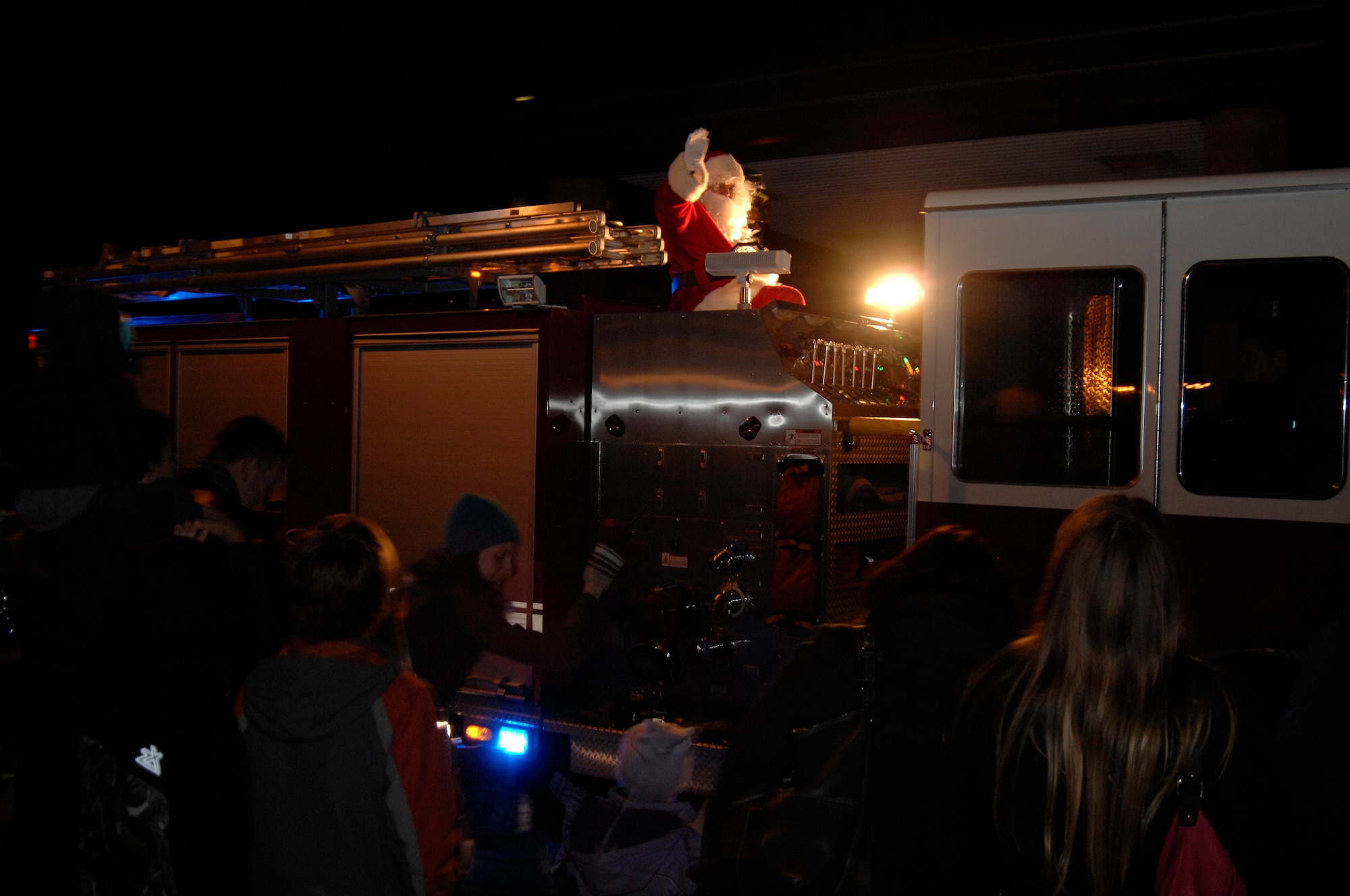 ROYAL AIR FORCE LAKENHEATH, England - Santa Claus arrives on a 48th Fighter Wing fire truck during the Christmas tree lighting ceremony, Dec. 2, 2011. In addition to Santa?s visit, the ceremony featured caroling, cookies and hot chocolate. (U.S. Air Force photo by Staff Sgt. David Dobrydney)