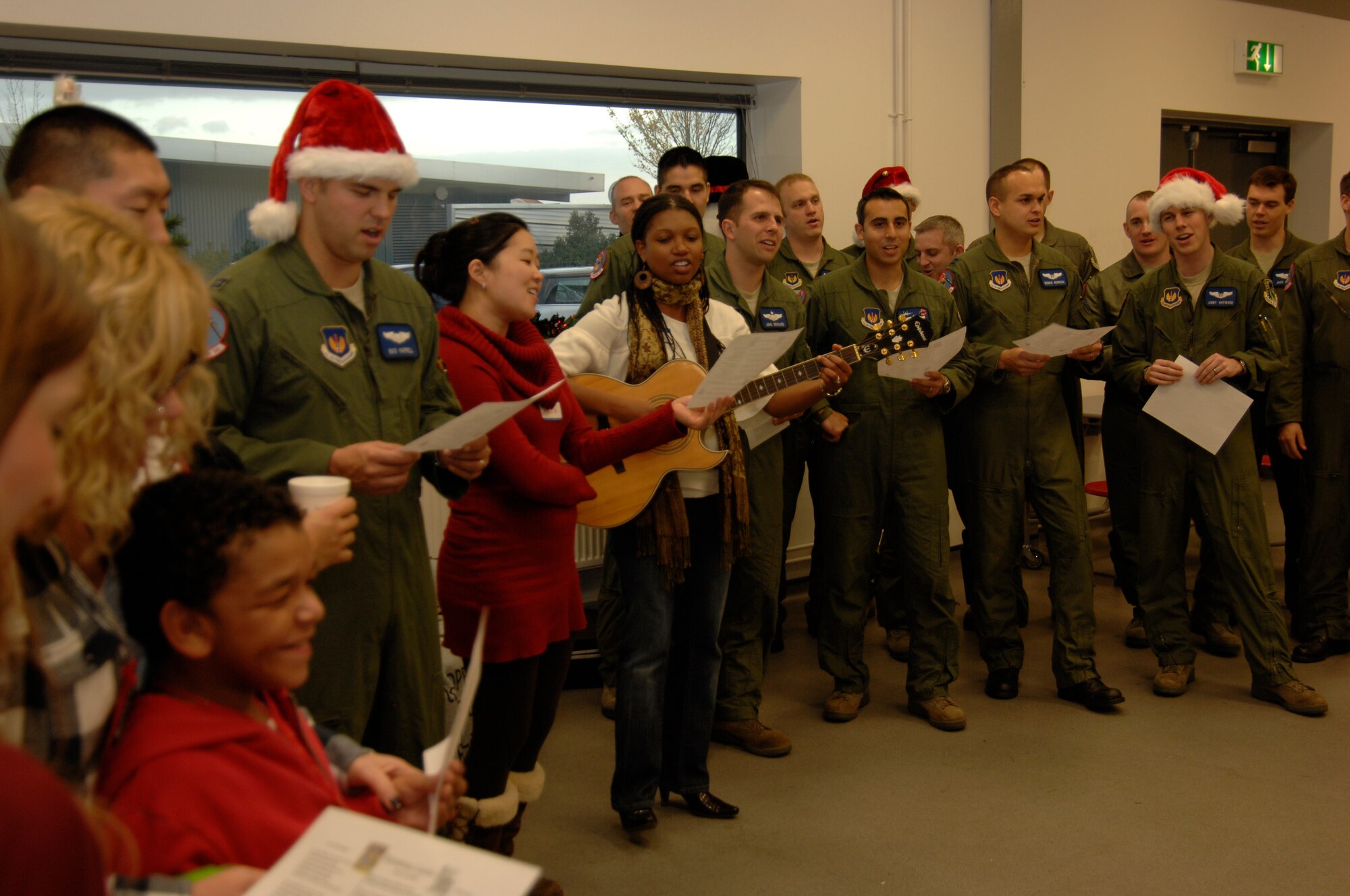 DUXFORD IMPERIAL WAR MUSEUM, England - Members of the 492nd Fighter Squadron and families sing carols at the 492nd Christmas party Dec. 3, 2011. The party was hosted for 50 children from U.K. hospitals and featured crafts, games, caroling and a visit from Santa Claus. (U.S. Air Force photo by Staff Sgt. David Dobrydney)