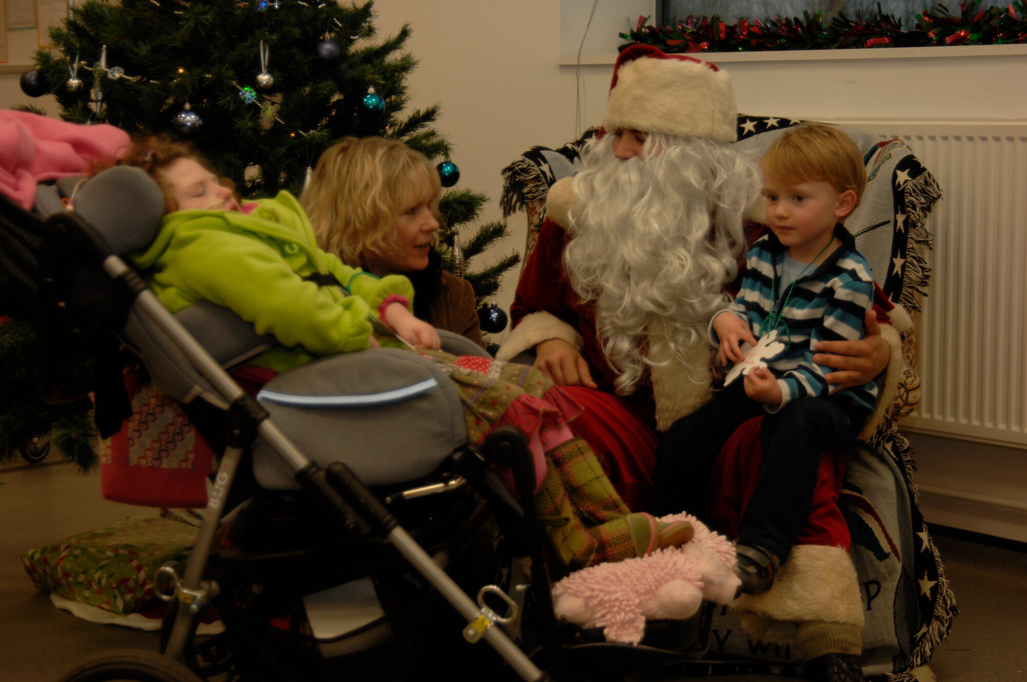 DUXFORD IMPERIAL WAR MUSEUM, England - Guy Brown, 5, his mother Amanda and sister Amy visit with Santa Claus during the 492nd Fighter Squadron Christmas party, Dec. 3, 2011. The party was hosted for 50 children from U.K. hospitals and featured crafts, games and caroling. (U.S. Air Force photo by Staff Sgt. David Dobrydney)