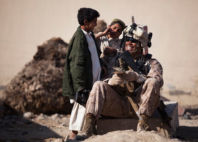 Sgt. Marcus Martin, a 32-year-old squad leader with Guard Force Platoon, 3rd Battalion, 3rd Marine Regiment and native of Charlottesville, Va., practices Pashto with Afghan boys while providing security outside the district  center here, Nov. 28. Guard Force isn’t a traditional infantry platoon. It’s a melting pot of Marines from various occupational specialties that functions as the main security element for the battalion headquarters at Forward Operating Base Delhi. During their seven-month deployment, the Guard Force Marines will labor through an endless cycle of standing post and conducting security patrols in the local area. In their down time, they stand ready to function as a quick reaction team.