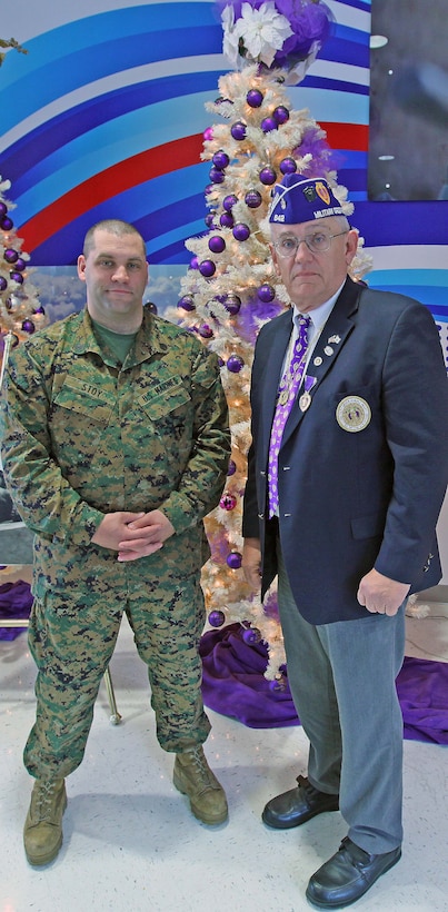 Staff Sgt. Daniel G. Stoy, an infantry unit leader with 8th Marine Regiment, 2nd Marine Division and Verl H. Matthews, the commander of the Military Order of the Purple Heart Beirut Memorial Chapter 642, stand in front of the Purple Heart Memorial Trees at the Marine Corps Base Camp Lejeune, N.C., Post Exchange. The trees have 530 ornaments with the names of service members who have been killed in action.