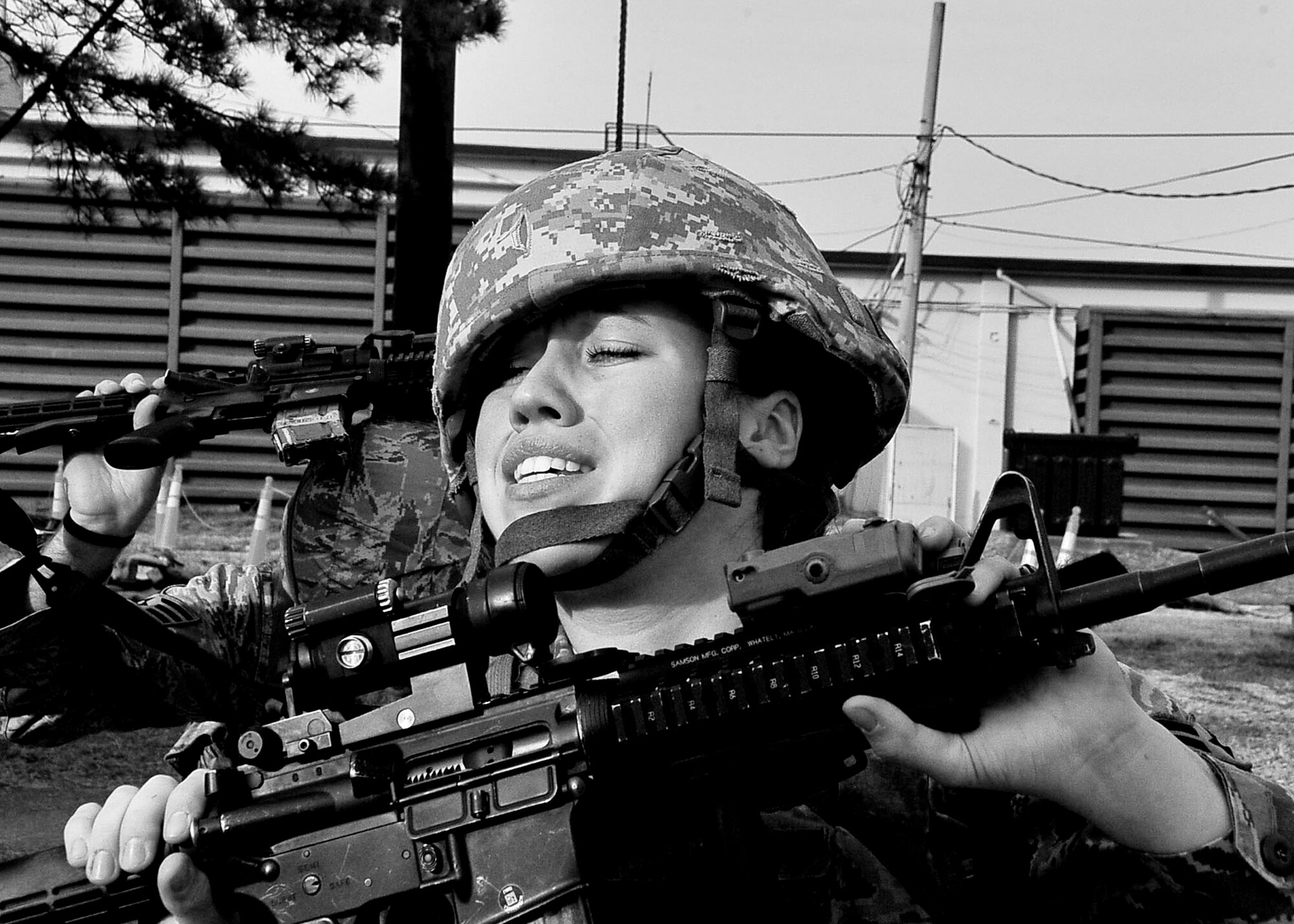 An Airman from the 51st Security Forces Squadron struggles to place her weapon above her head during the confidence course Dec. 05, 2011.  During the confidence course members answer knowledge questions, perform sprints, tire rolls, low crawl for 30 yards, maneuver over an 8-foot wall, litter carry and injured team member for 400 meters and compete in a weapons challenge. (U.S. Air Force photo/Senior Airman Adam Grant)