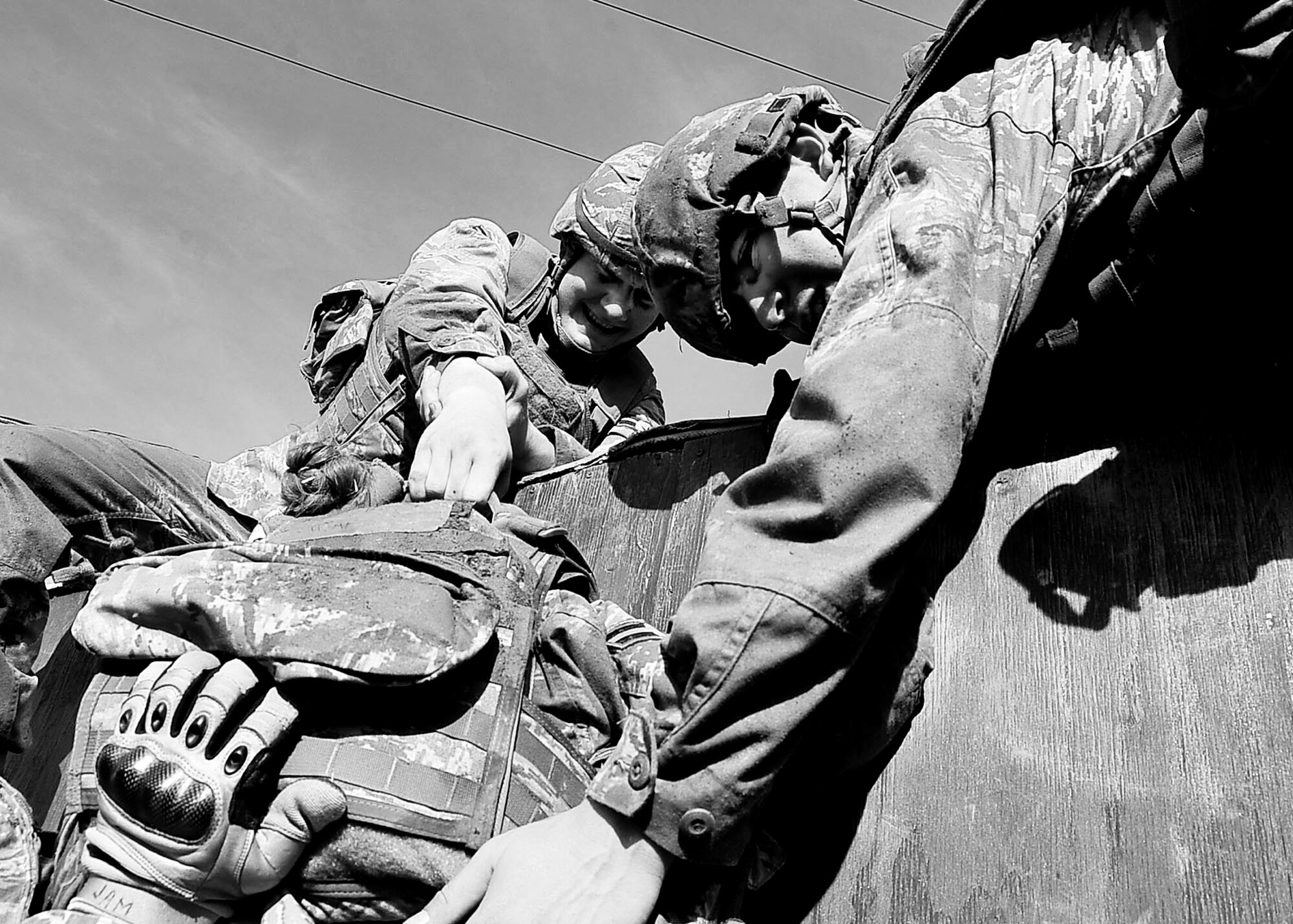 51st Security Forces Squadron personnel pull a team member over an 8-foot wall during the Combat Readiness course held Dec. 05, 2011. During the confidence course members answer knowledge questions, perform sprints, tire rolls, low crawl for 30 yards, maneuver over an 8-foot wall, litter carry and injured team member for 400 meters and compete in a weapons challenge. (U.S. Air Force photo/Senior Airman Adam Grant)