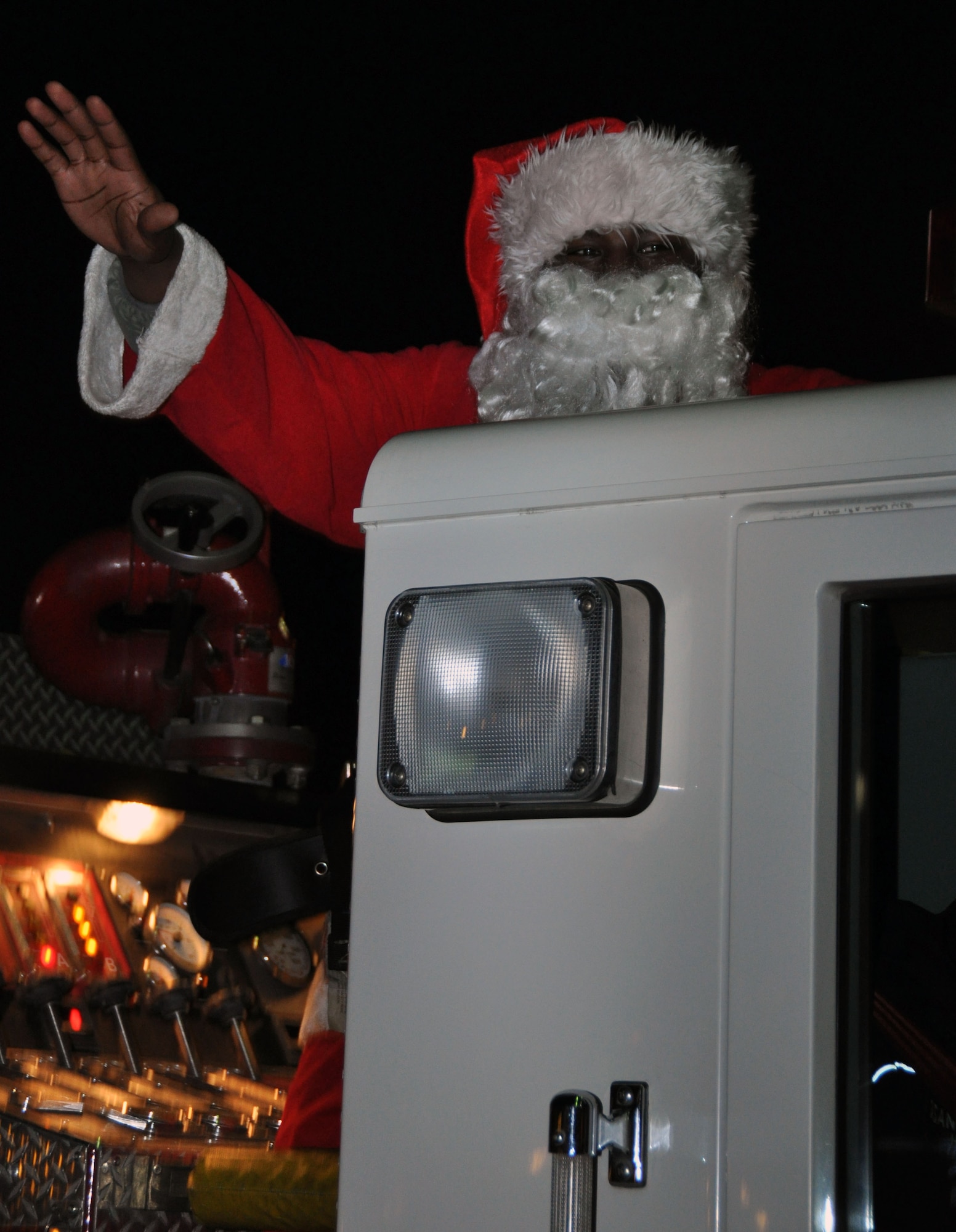 Santa Clause greets members of Team Osan as he arrives by fire truck during the base tree lighting ceremony Dec. 7, 2011. Approximately 400 members of Team Osan enjoyed music, caroling and a chance to meet Santa Clause. (U.S. Air Force photo/Airman 1st Class Michael Battles)