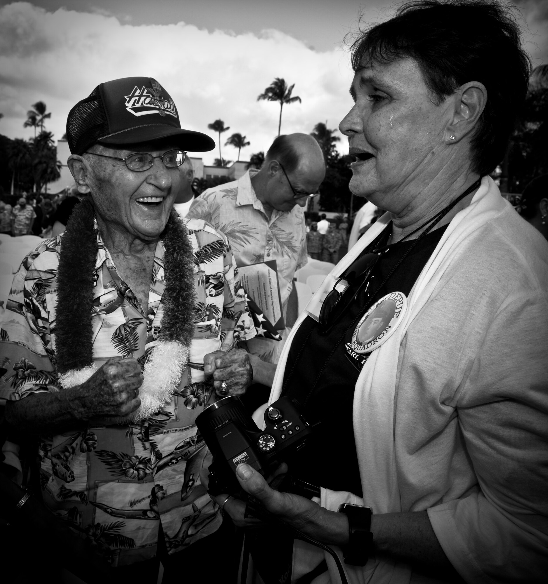 Ret. Col. Andrew Kowalski, Hickam Field survivor, and Judie Paranuk, the daughter of Bill Depue, also a Hickam Field survivor, are elated to meet each other as Kowalski reminisces about Paranuk's father at the 70th Anniversary Remembrance Ceremony of the attacks on Hickam Field, Dec. 7, 2011. Paranuk flew from Virginia to honor her late father at the ceremony. She wore a badge with her father's name and photo in hopes that one of the other survivors would recognize him, and Kowalski did. In 1941, Kowalski was the 14th Reconnaissance Squadron first sergeant, and following the attacks, he reported to the Wing building to assist his commander in providing direction and guidance. (U.S. Air Force photo/Senior Airman Lauren Main)