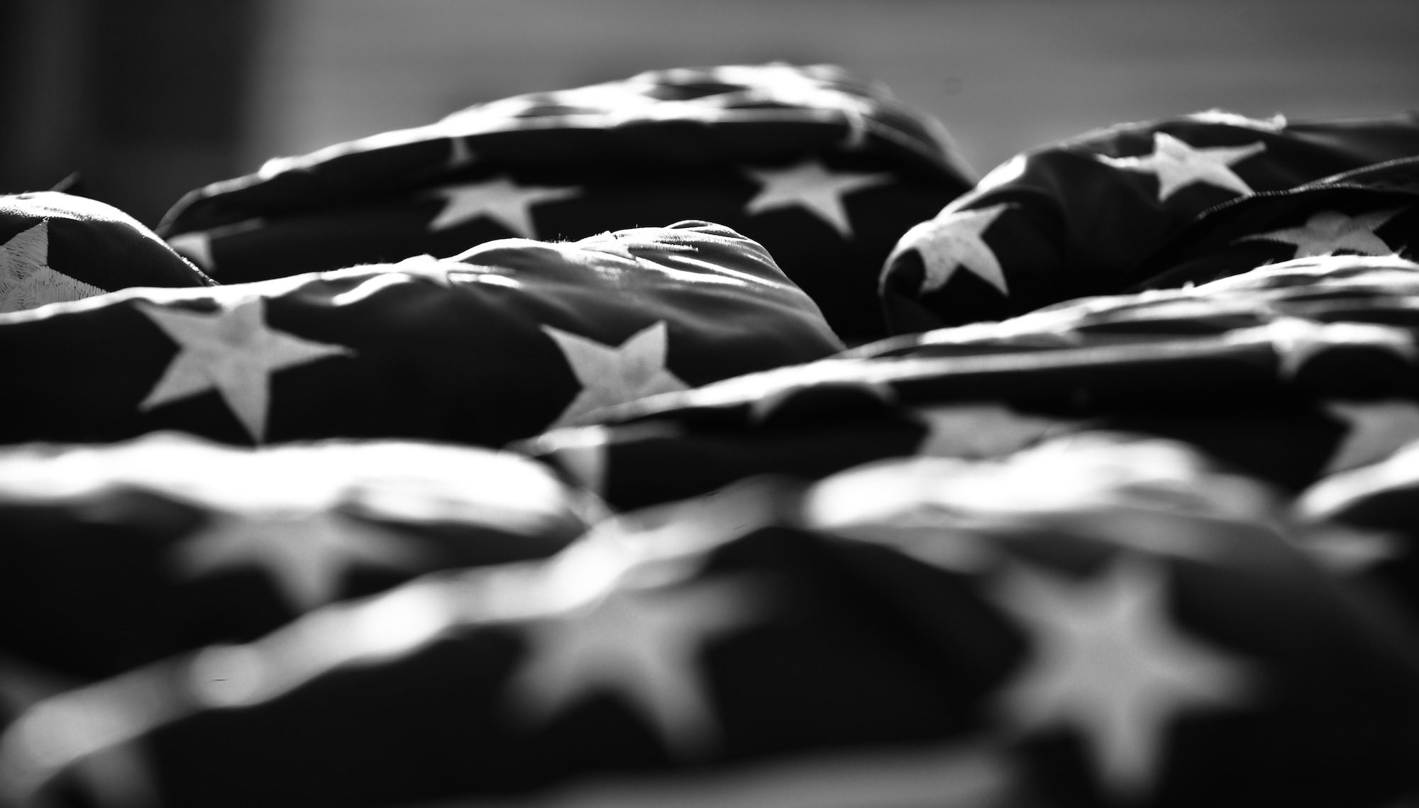 Folded flags sit atop a table, waiting to be presented to Hickam Field survivors at the 70th Anniversary Remembrance Ceremony on Joint Base Pearl Harbor-Hickam, Hawaii, Dec. 7, 2011.  Each survivor was presented a flag and a certificate noting all the military installations and locations that the flag had been flown. (U.S. Air Force photo/Senior Airman Lauren Main)