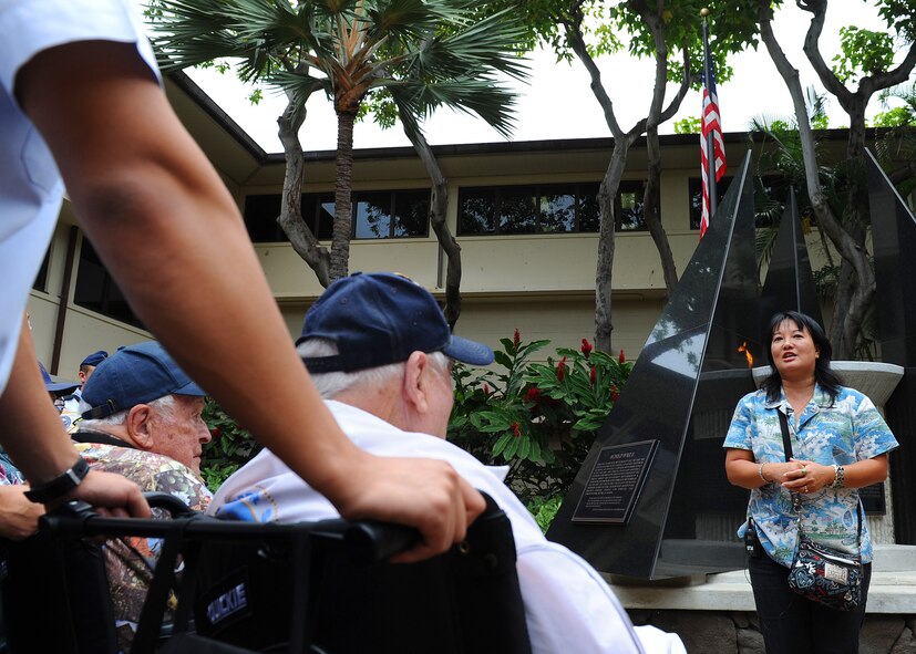 Jessie Higa, Hickam Field history research volunteer, speaks to a group of Pearl Harbor survivors in the Courtyard of Heroes located in the Pacific Air Forces Headquarters building, Joint Base Pearl Harbor-Hickam, Hawaii, Dec. 6, 2011.  Some of the survivors from the attack were present to attend the 70th Anniversary Commemorative Ceremony, hosted by the 15th Wing at the joint base. (U.S. Air Force photo/Tech. Sgt. Jerome S. Tayborn/Released)