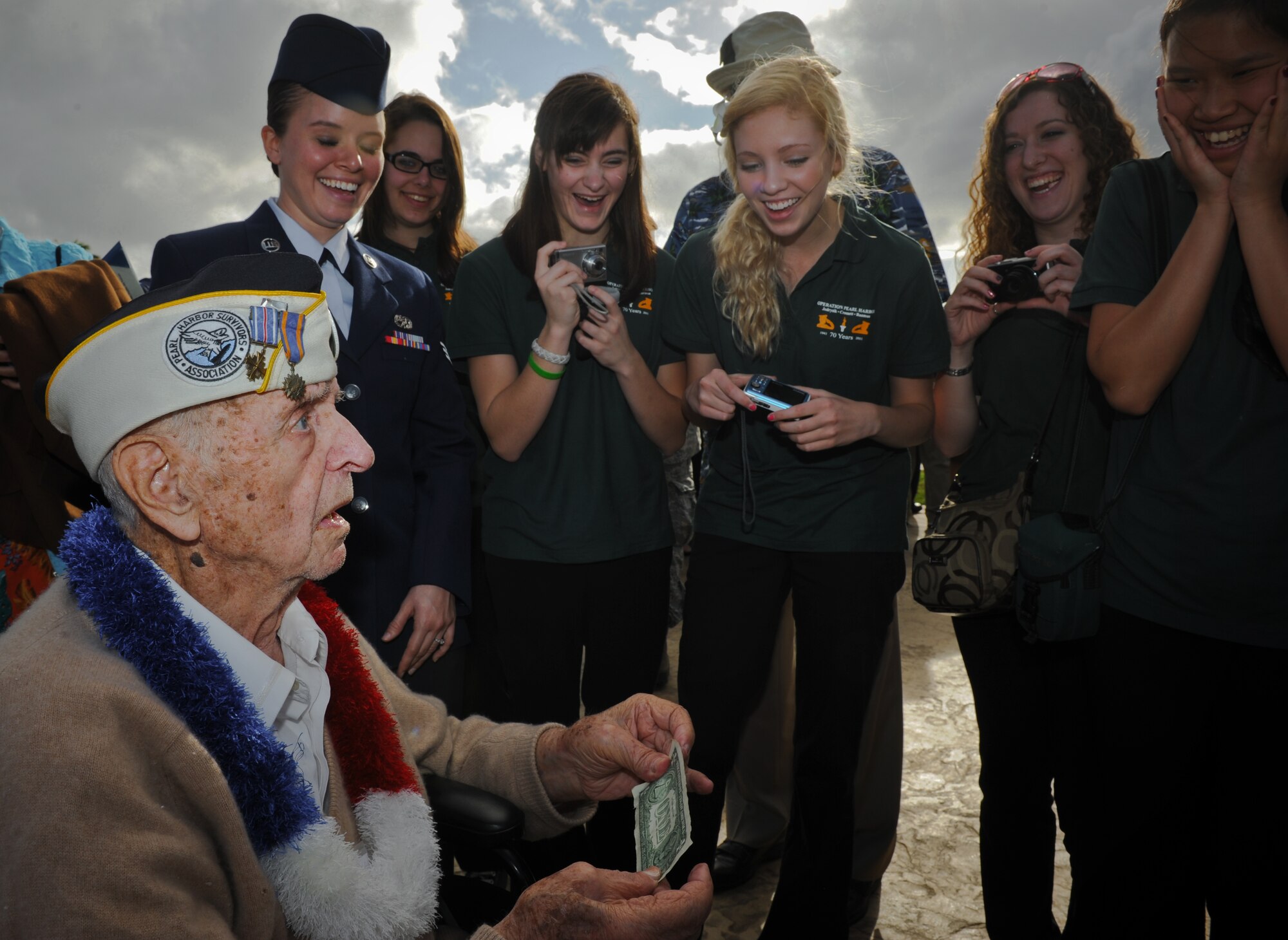 Former Tech. Sgt. Lou Roffman performs magic tricks for young high school students from Manchester Central High School, New Hampshire, on Joint Base Pearl Harbor-Hickam, Hawaii, Dec. 7, 2011. Roffman was attending the 70th Anniversary Remembrance Ceremony of the attacks on Hickam Field. Roffman was a flight engineer assigned to the 31st Bomb Squadron. The Manchester HS band attended the ceremony to honor three alumni who were killed in action on Dec. 7, 1941. (U.S. Air Force photo/Senior Airman Lauren Main/Released)
