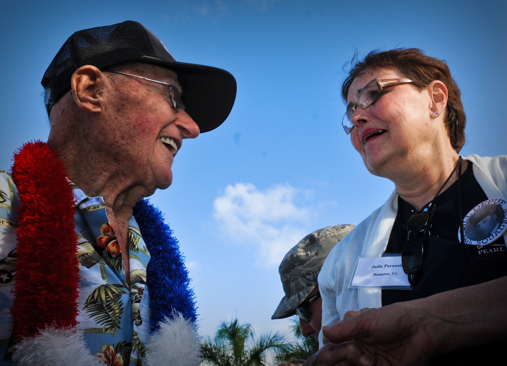 Ret. Col. Andrew Kowalski, Hickam Field survivor, and Judie Paranuk, the daughter of Bill Depue, also a Hickam Field survivor, are elated to meet each other as Kowalski reminisces about Paranuk's father at the 70th Anniversary Remembrance Ceremony of the attacks on Hickam Field, Dec. 7, 2011, Joint Base Pearl Harbor-Hickam, Hawaii. Paranuk flew from Virginia to honor her late father at the ceremony. She wore a badge with her father's name and photo in hopes that one of the other survivors would recognize him, and Kowalski did. In 1941, Kowalski was the 14th Reconnaissance Squadron first sergeant, and following the attacks, he reported to the Wing building to assist his commander in providing direction and guidance. (U.S. Air Force photo/Senior Airman Lauren Main/Released)
