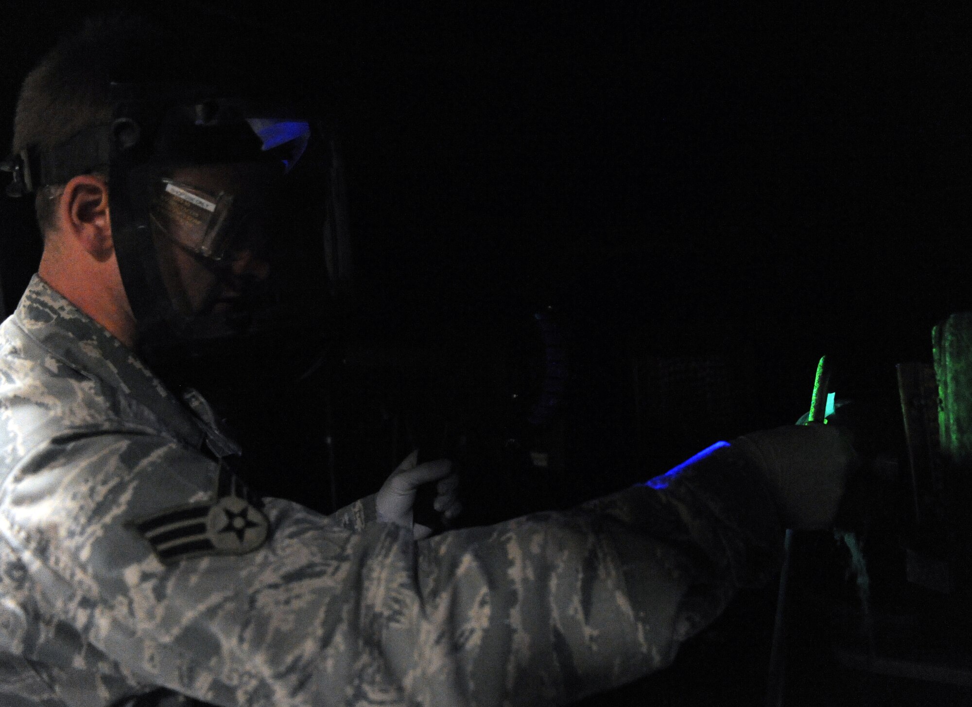 WHITEMAN AIR FORCE BASE, Mo. -- Senior Airman Brandon Gerst looks for surface defects under a black light Dec. 2. The black light causes particles to become florescent which are unseen to the human eye. Gerst is a non-destructive inspection technician assigned to the 509th Maintenance Squadron. (U.S. Air Force photo/Senior Airman Laura Goodgame) 