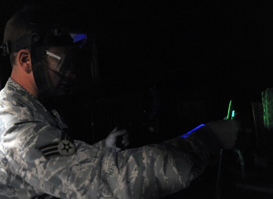 WHITEMAN AIR FORCE BASE, Mo. -- Senior Airman Brandon Gerst looks for surface defects under a black light Dec. 2, 2011. The black light causes particles, which are unseen to the human eye, to become florescent. Gerst is a non-destructive inspection technician assigned to the 509th Maintenance Squadron. (U.S. Air Force photo by Senior Airman Laura Goodgame) 