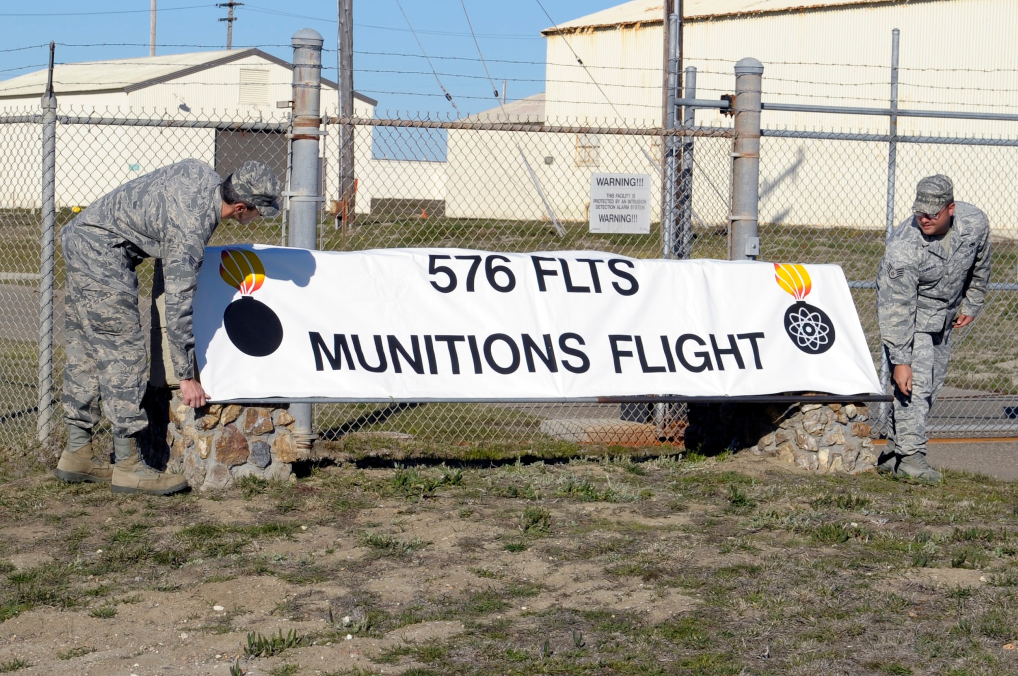 VANDENBERG AIR FORCE BASE, Calif. -- Airmen from 798th Munitions Maintenance Group Detachment 1, reveal their unit’s sign here Tuesday, Dec. 6, 2011. The deactivation is due to a major command change and realignment of functions placing the command, control and authority for the operational mission with the 576th Flight Test Squadron here. (U.S. Air Force photo/Jerry E. Clemens Jr.)

