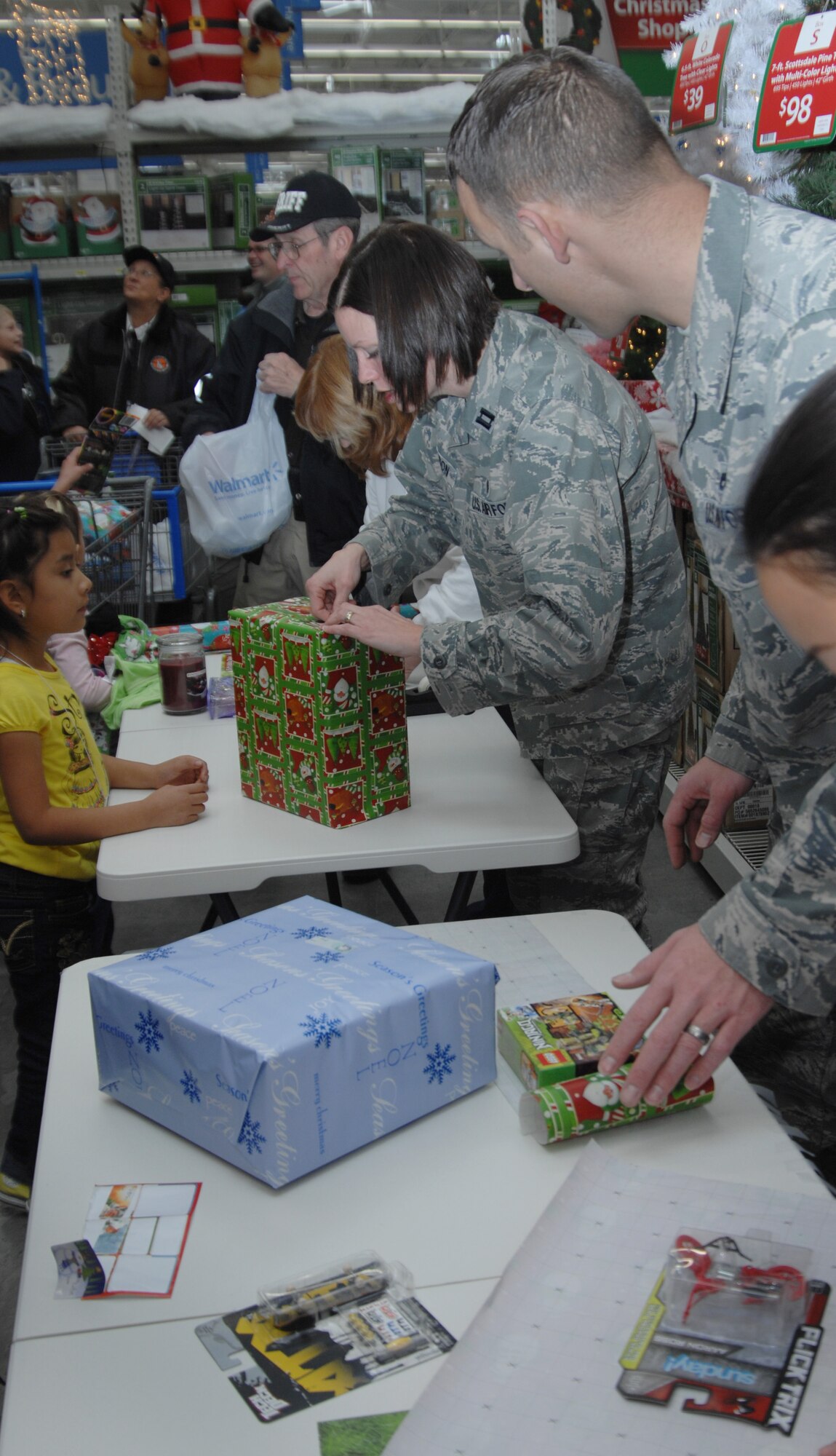 Volunteers from Mountain Home Air Force Base, Idaho, wrap gifts for children Dec. 3, 2011, at the 15th annual Shop with a Cop event in Mountain Home, Idaho. More than 100 children and local military and first response agencies participated in the event which supports the local area children and their families. (U.S. Air Force photo by Senior Airman Benjamin Sutton)  