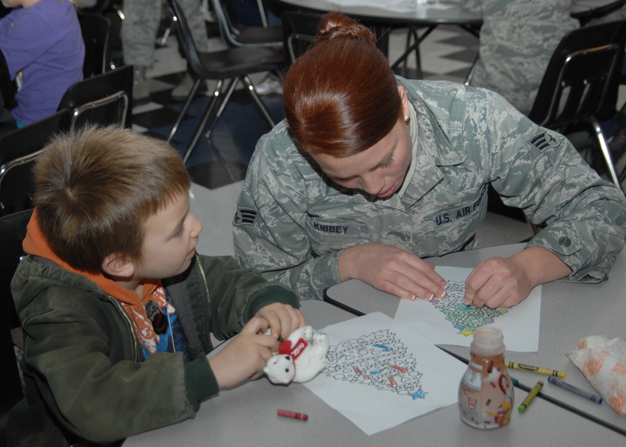 Senior Airman Scottlyn Kibbey, 366th Security Forces Squadron response force member, spends time coloring with Ethan during the morning meet-and-greet session for the 15th annual Shop with a Cop event Dec. 3, 2011, in Mountain Home, Idaho. Thirty-four members from the 366th Security Forces Squadron and other Gunfighters, along with the Mountain Home Police and Elmore County Sheriff’s Departments, participated in this year’s event. (U.S. Air Force photo by Senior Airman Benjamin Sutton)