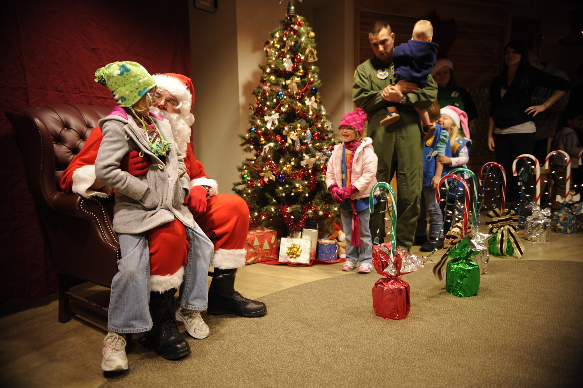 VANDENBERG AIR FORCE BASE, Calif. -- Team V members sit with Santa during the base tree lighting event here Tuesday, Dec. 6, 2011.  The base celebrated the holidays with the lighting of the Christmas tree and a surprise visit from Santa. (U.S. Air Force photo/Staff Sgt. Andrew Satran) 

 