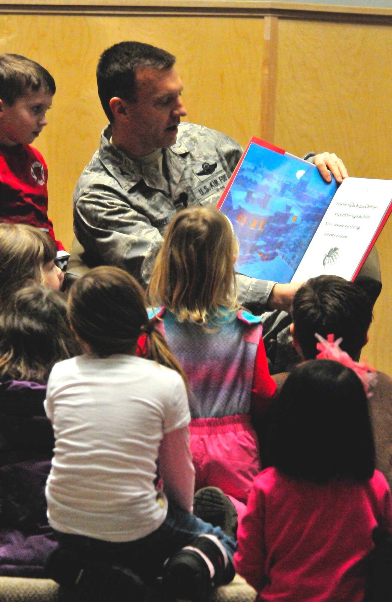 Col. Lynn Scheel, 354th Fighter Wing vice commander, reads "’Twas the Night Before Christmas" to Eielson children at the base chapel here Dec. 1.  Families gathered for the lighting of the base holiday tree, followed by the Family Holiday Celebration, sponsored by the 354th Force Support Squadron, which featured music, food and a visit by Santa Claus. (U.S. Air Force photo/Staff Sgt. Miguel Lara III)