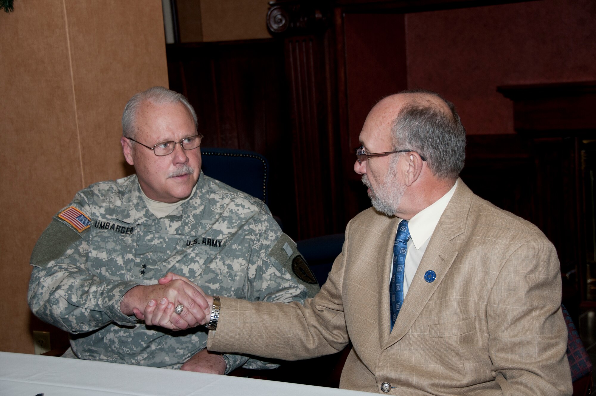 Terre Haute, Ind. – Maj. Gen. R. Martin Umbarger, The Adjutant General of Indiana, and Dr. Daniel J. Bradley, President, Indiana State University, shake hands after signing a memorandum of understanding at Indiana State University on December 5, 2011. The agreement allows ISU to use restricted air space, runways and other resources at Camp Atterbury-Muscatatuck Center for Complex Operation, in southeastern Indiana. Photo by Senior Master Sergeant John S. Chapman