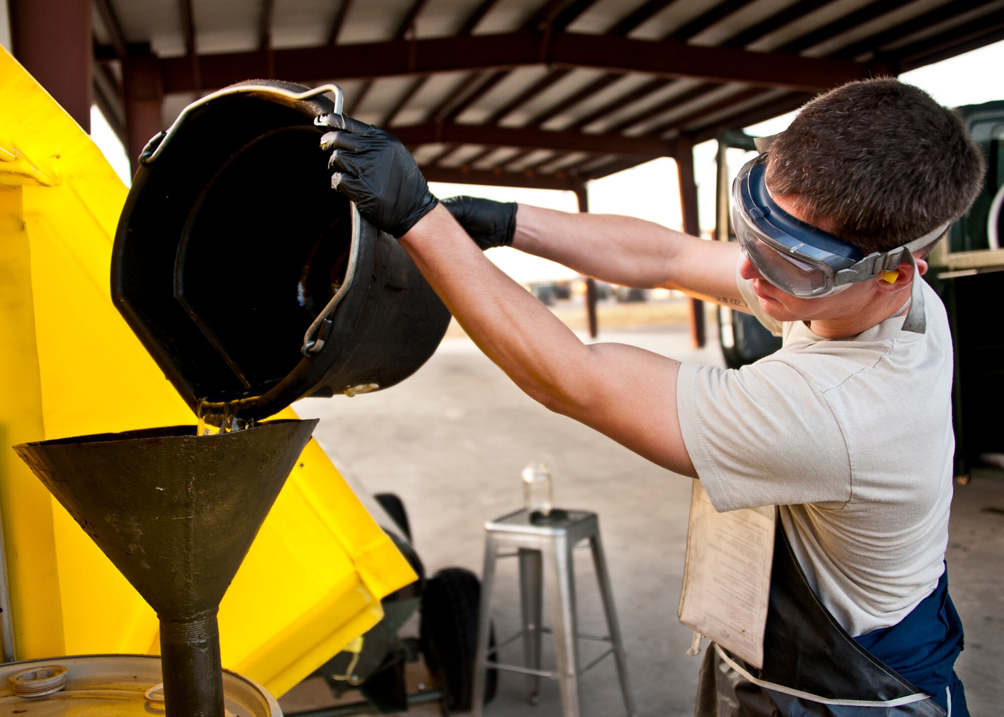 Staff Sgt. Chad Gagnon, of the 96th Logistics Readiness Squadron, pours the fuel drained from the bottom of the tank of an R-11 truck into a storage container during a morning inspection at Eglin Air Force Base, Fla.  Each morning, Airmen from the petroleum, oil and lubricants flight inspect every fuel truck in the fleet to include checking the seals, lights, the hoses for tears or gashes and taking fuel samples from the bottom of each tank.  (U.S. Air Force photo/Samuel King Jr.)