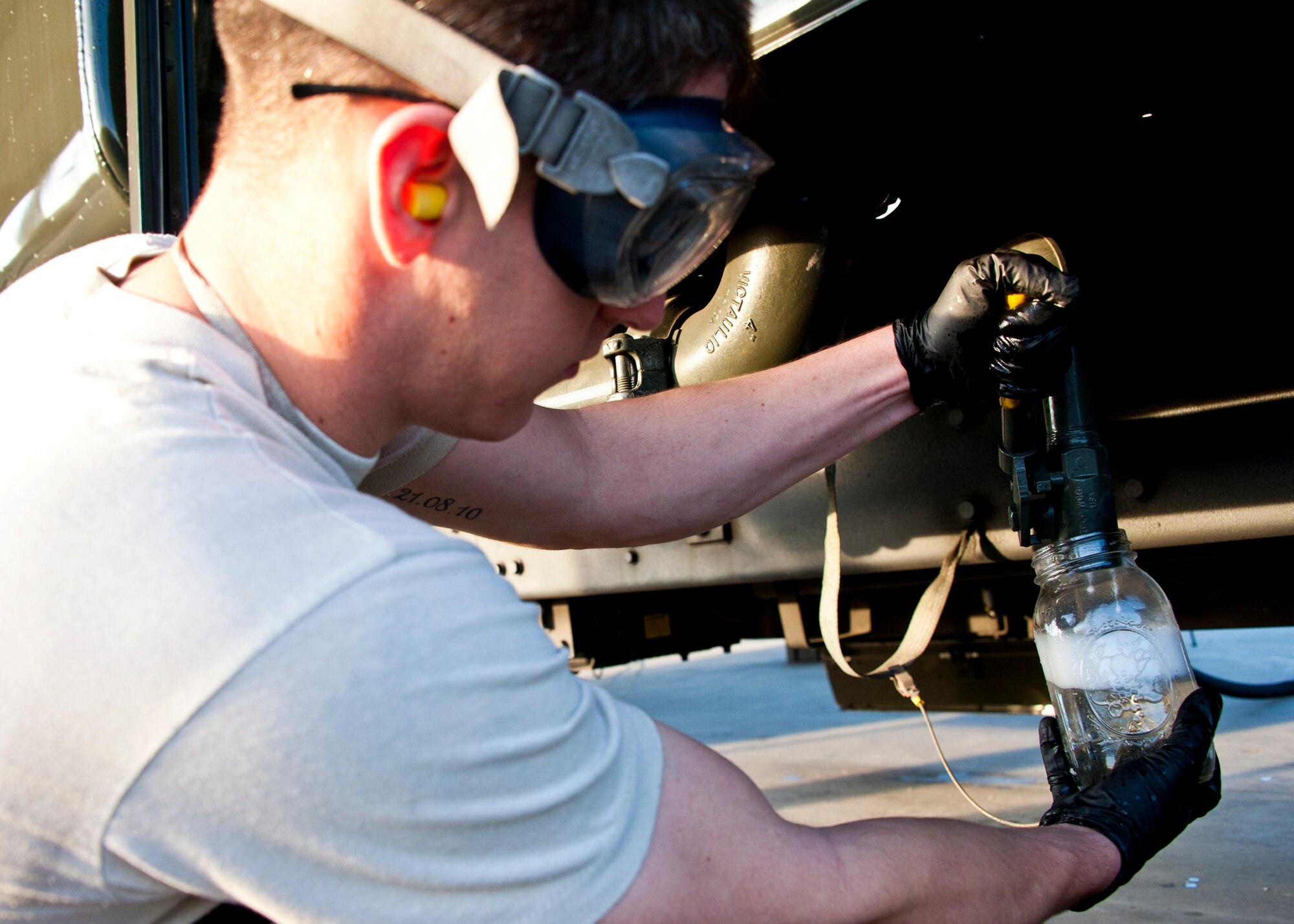 Staff Sgt. Chad Gagnon, of the 96th Logistics Readiness Squadron, drains the fuel from the bottom of the tank from an R-11 truck during its morning inspection at Eglin Air Force Base, Fla.  Each morning, Airmen from the petroleum, oil and lubricants flight inspect every fuel truck in the fleet to include checking the seals, lights, the hoses for tears or gashes and taking fuel samples from the bottom of each tank.  (U.S. Air Force photo/Samuel King Jr.)