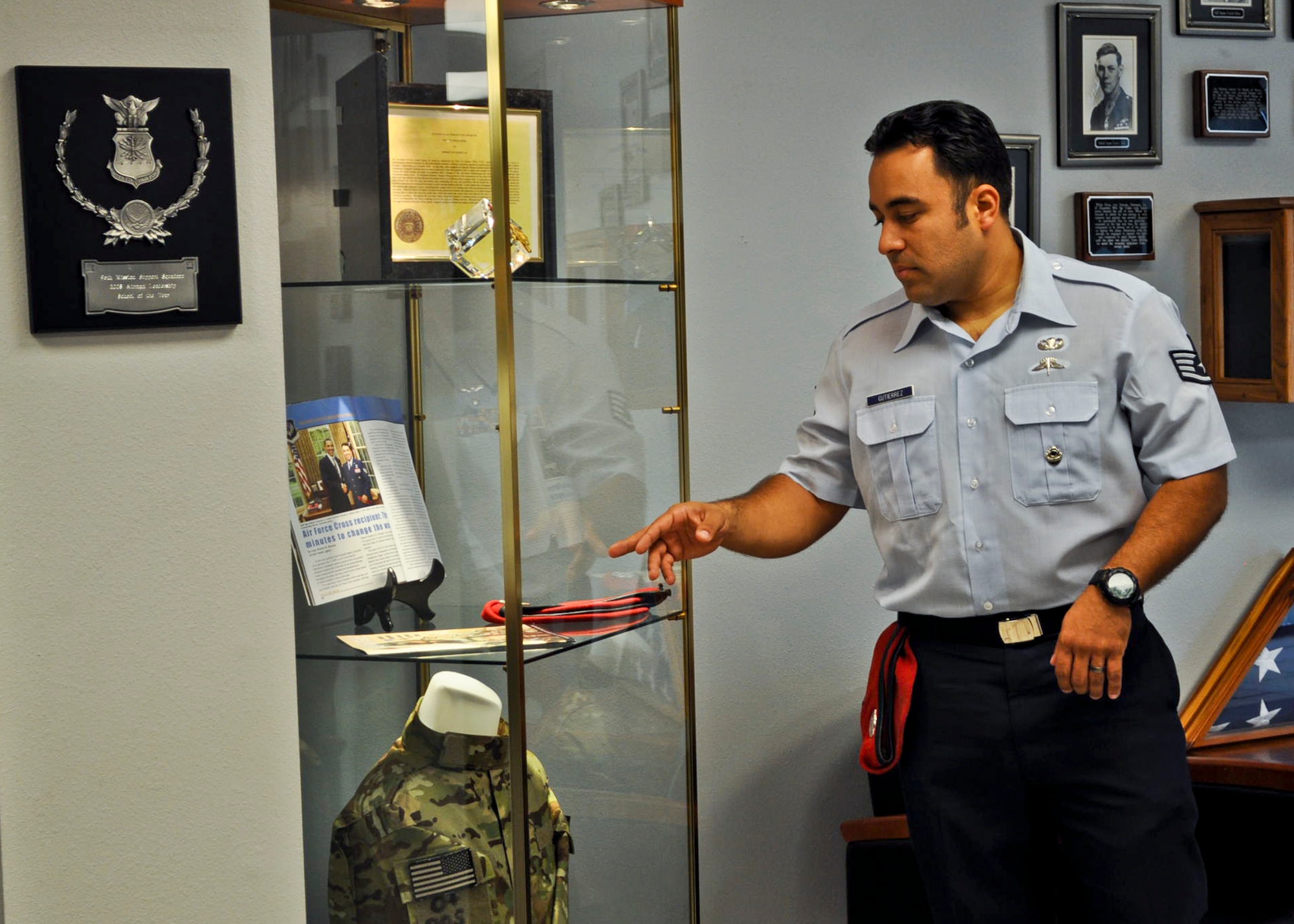 Staff Sgt. Robert Gutierrez looks at the display case containing his Air Force Cross citation and other memorabilia, which was dedicated to him at the Enlisted Professional Development Center Dec. 5 at Eglin Air Force Base, Fla.  Gutierrez received the award “for extraordinary heroism against an armed enemy of the United States in Harat Province, Afghanistan” from President Barack Obama on Oct. 5, 2009.  During a nighttime raid, Gutierrez, assigned as a special tactics combat controller to an Army Special Forces detachment, was shot in the chest.  Though in intense pain, he engaged Taliban fighters with gunfire and directed two strafe runs, which decimated the enemy force and allowed his team to escape the kill zone. Gutierrez is a member of the Special Tactics Training Squadron at Hurlburt Field. (Courtesy photo)    