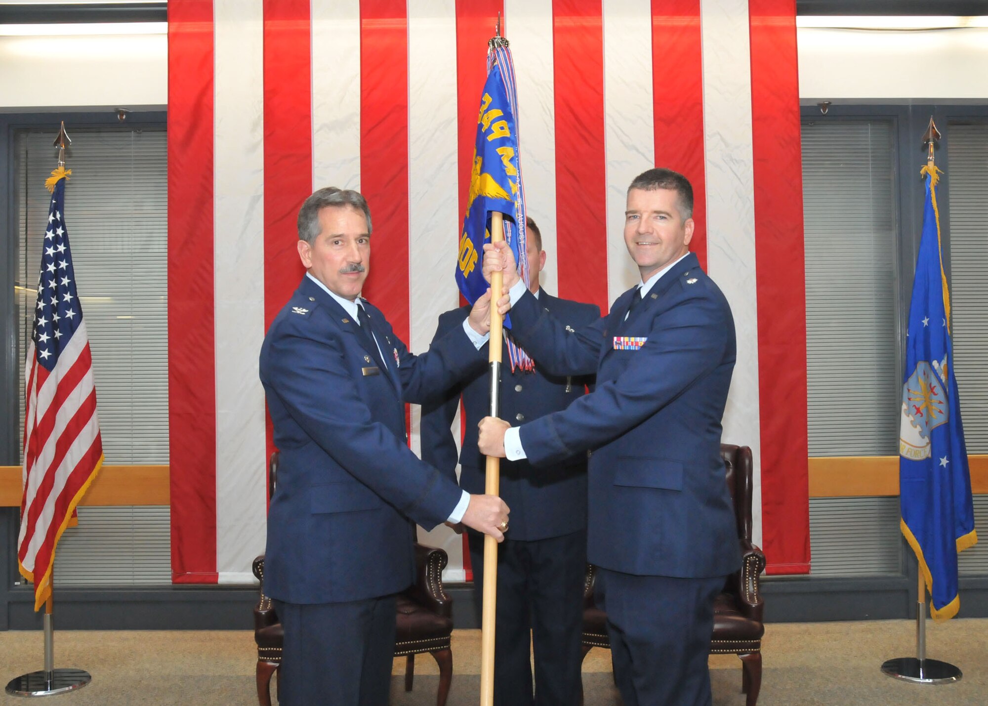TRAVIS AIR FORCE BASE, Calif. -- Col. Melvin Giddings, 349th Maintenance Group commander, passes the 349th Maintenance Operations Flight guidon to Lt. Col. Joseph Orcutt. Lt. Col Orcutt assumed command of the 349th MOF after a number of years as an IMA assigned to Hill AFB, Utah. (U.S. Air Force photo/Master Sgt. Robert Wade)