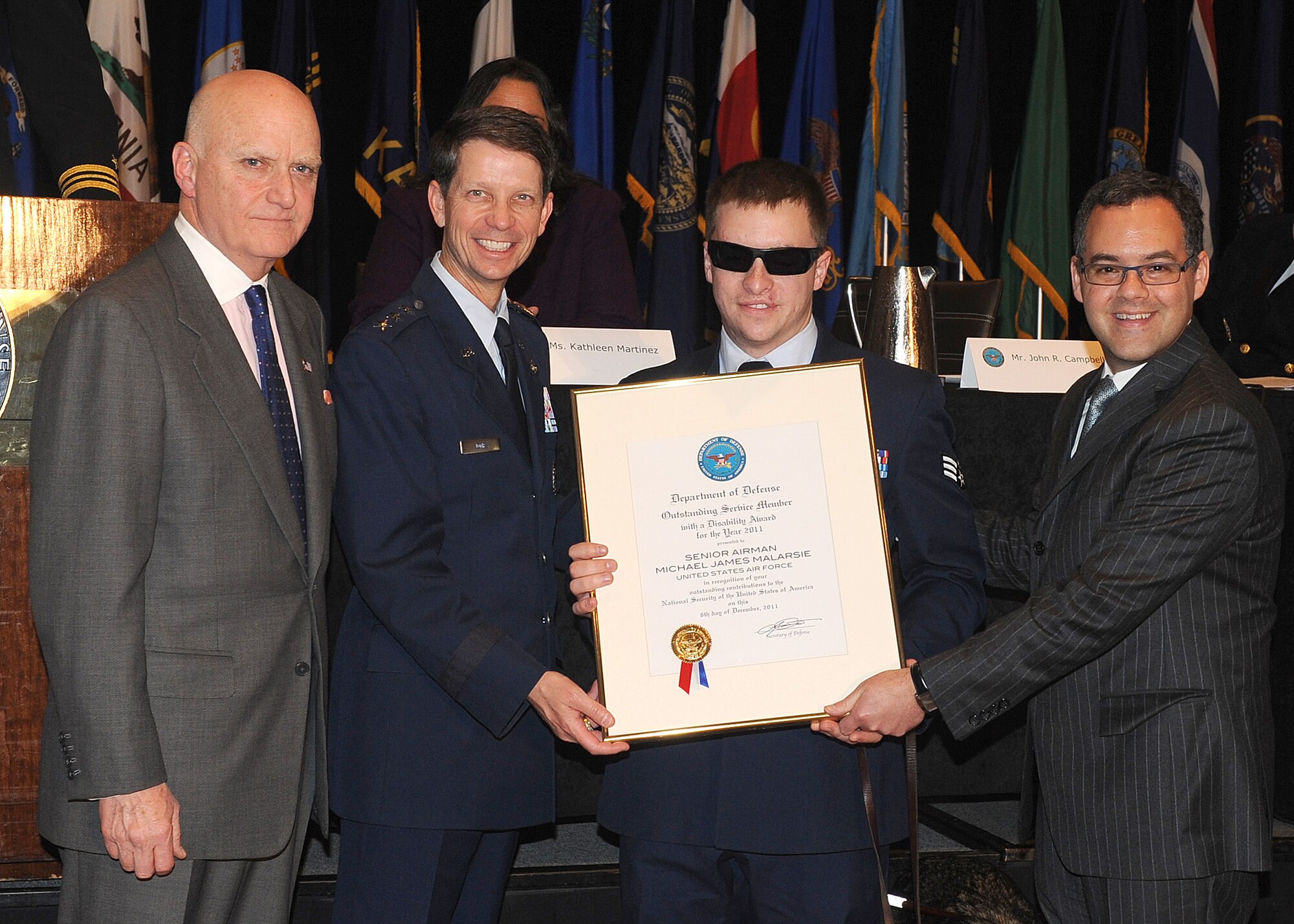 Senior Airman Michael J. Malarsie receives his Department of Defense Outstanding Service Member with a Disability award Dec. 6, 2011, from John R. Campbell, Lt. Gen. Darrell Jones and Daniel Ginsberg during the 31st Annual DOD Disability Awards ceremony at the Hyatt Regency Hotel in Bethesda, Md. The award highlights the valuable contributions to national security made by individuals with disabilities. Malarsie is the recovering airmen mentorship program administrator, Campell is the Deputy Assistant Secretary of Defense for Wounded Warrior Care and Transition Policy, Jones is the Air Force deputy chief of staff for manpower, personnel and services and Ginsberg is the Air Force assistant secretary for manpower and reserve affairs. (U.S. Air Force photo/Master Sgt. Raheem Moore)