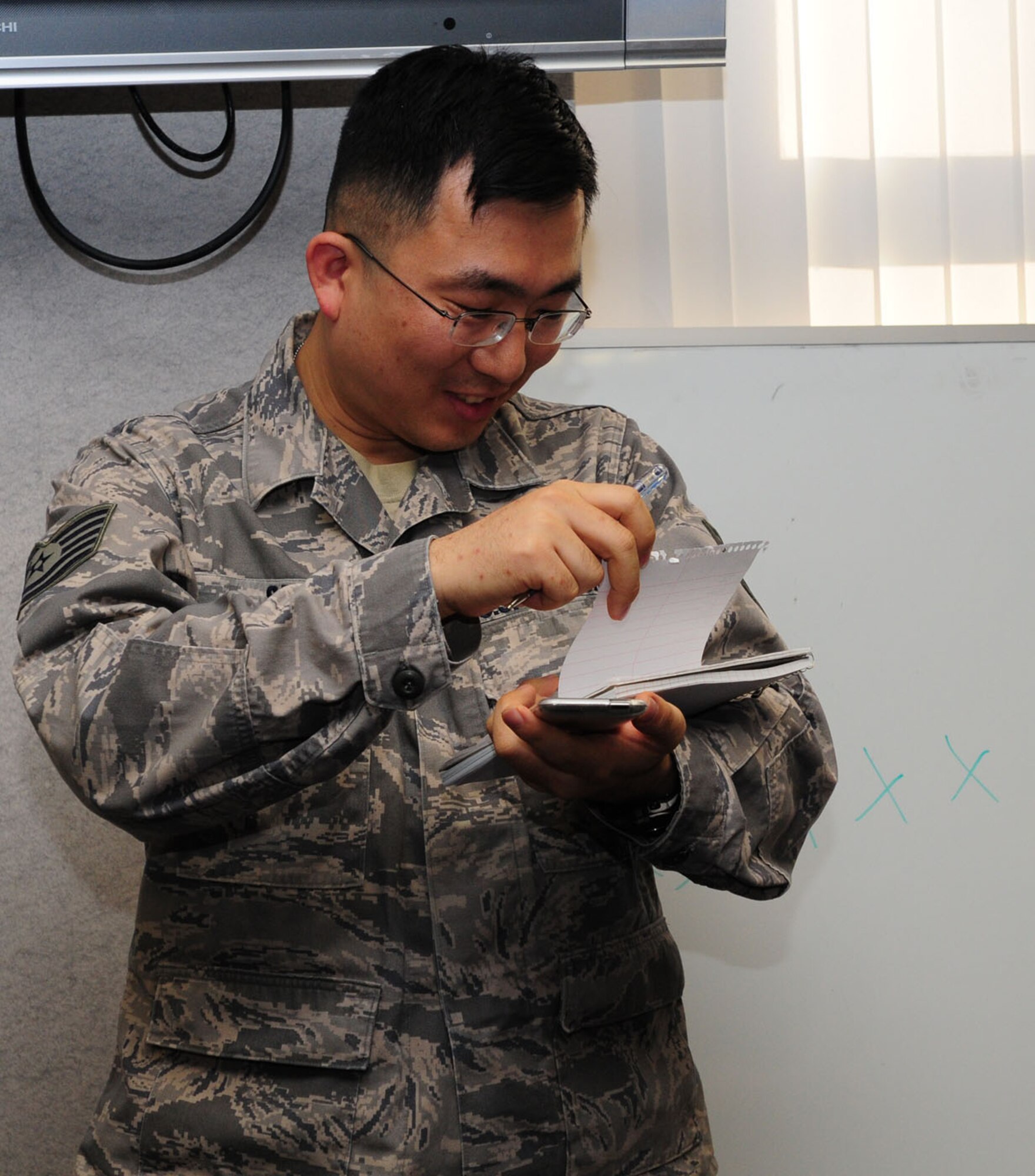 RAF MILDENHALL, England -- Tech. Sgt. Felix Seo, 100th Comptroller Squadron, prepares to write down a word which a member from both teams has to draw and show to the next person in line, in a teambuilding challenge here Dec. 2, 2011. The last person in the line on each team had to shout out what they thought the picture was supposed to be. (U.S. Air Force photo/Karen Abeyasekere)