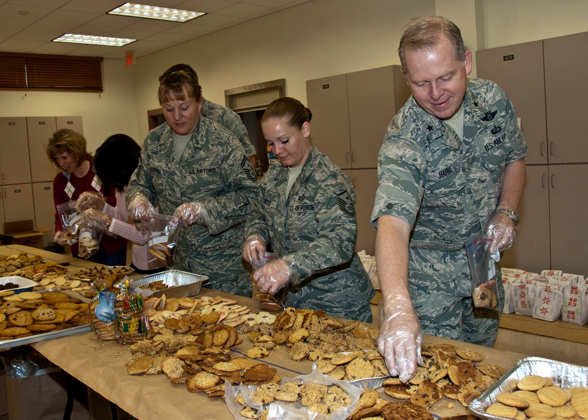 Brig. Gen. David Harris, the Air Armament Center vice-commander, leads a group of volunteers in bagging cookies for delivery to dorm residents at this year’s “Team Eglin Holiday Cookie Caper”at Eglin Air Force Base, Fla. Dec. 7.  (U.S. Air Force photo/Kevin Gaddie)