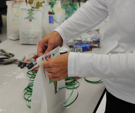 Phylis McComb, Team Charleston Spouses Club member, ties a bag during the Annual Cookie Drop Dec.6 at the Joint Base charleston-Air Base Chapel Annex. The cookie drop collected homemade cookies that were donated to Airmen and Sailors living in the dorms and to those who are deployed. (U.S. Air Force photo/Airman 1st Class Ashlee Galloway)