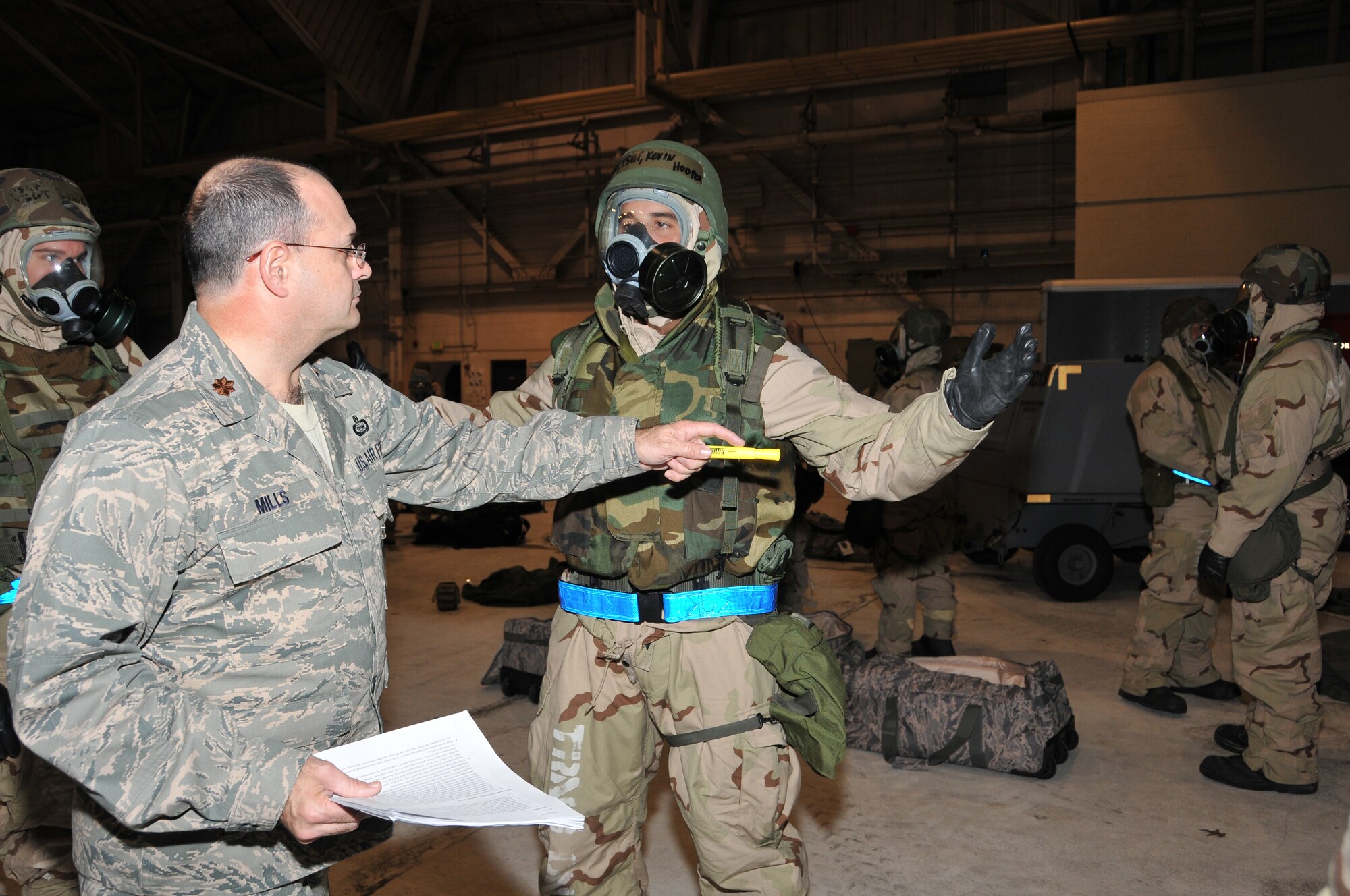 Maj. Bill Mills, 512th Airlift Wing Exercise Evaluation Team member, inspects the mission oriented protective posture of Tech. Sgt. Kevin Hooper, 512th Operations Group, inside a hangar on Dover Air Force Base, Del., Dec. 3. Members of the Liberty Wing will join their active-duty counterparts in an Operational Readiness Inspection slated for Dec. 7-14 in Gulfport, Miss.,where they will prove their ability to survive and operate in austere conditions.