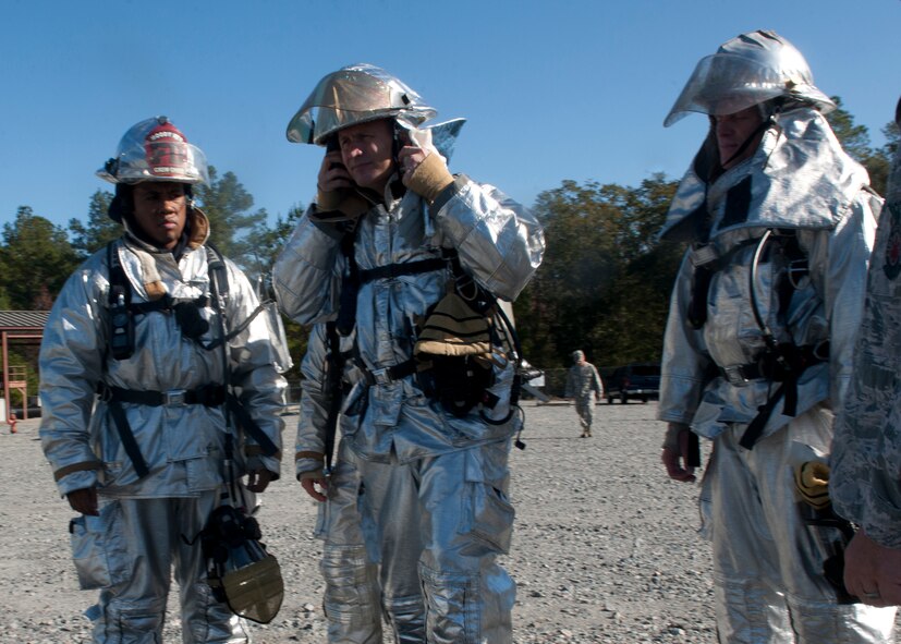 U.S. Air Force Col. Billy Thompson, 23rd Wing commander, center, and Chief Master Sgt. Frank Batten, 23rd Wing command chief, right, participate in an exercise with Airmen from the 23rd Civil Engineer Squadron to extinguish a burning “aircraft” at a training site called “The Pit” at Moody Air Force Base, Ga., Dec. 5, 2011. Thompson and Batten suited up with personal protective equipment and helped deter a live fire to experience how fire fighters operate during the event of an accident involving fire. (U.S. Air Force photo by Senior Airman Eileen Meier/Released)