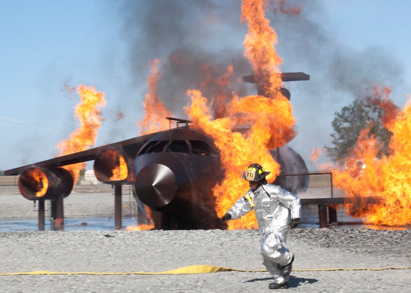 An Airman with the 23rd Civil Engineer Squadron fire department hurries to unravel a fire hose during a fire fighter training session at Moody Air Force Base, Ga., Dec. 5, 2011. U.S. Air Force Col. Billy Thompson, 23rd Wing commander, and Chief Master Sgt. Frank Batten, 23rd Wing command chief, also took part in the exercise to experience what a fire fighter goes through during accidents that involve fire. (U.S. Air Force photo by Senior Airman Eileen Meier/Released)