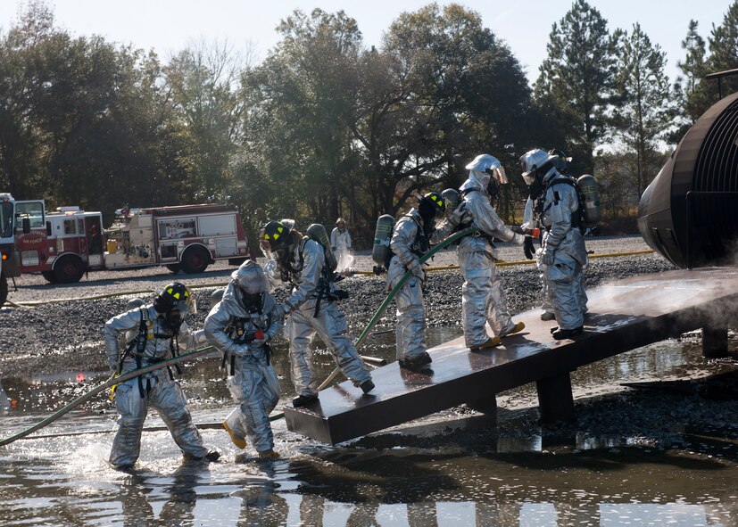 U.S. Air Force Col. Billy Thompson, 23rd Wing commander, Chief Master Sgt. Frank Batten, 23rd Wing command chief, and Airmen from the 23rd Civil Engineer Squadron fire department prepare to enter a burning “aircraft” structure during a fire fighter training session at Moody Air Force Base, Ga., Dec. 5, 2011. Members of the 23rd CES worked together to ensure the fire was extinguished and everyone exited safely. (U.S. Air Force photo by Senior Airman Eileen Meier/Released)