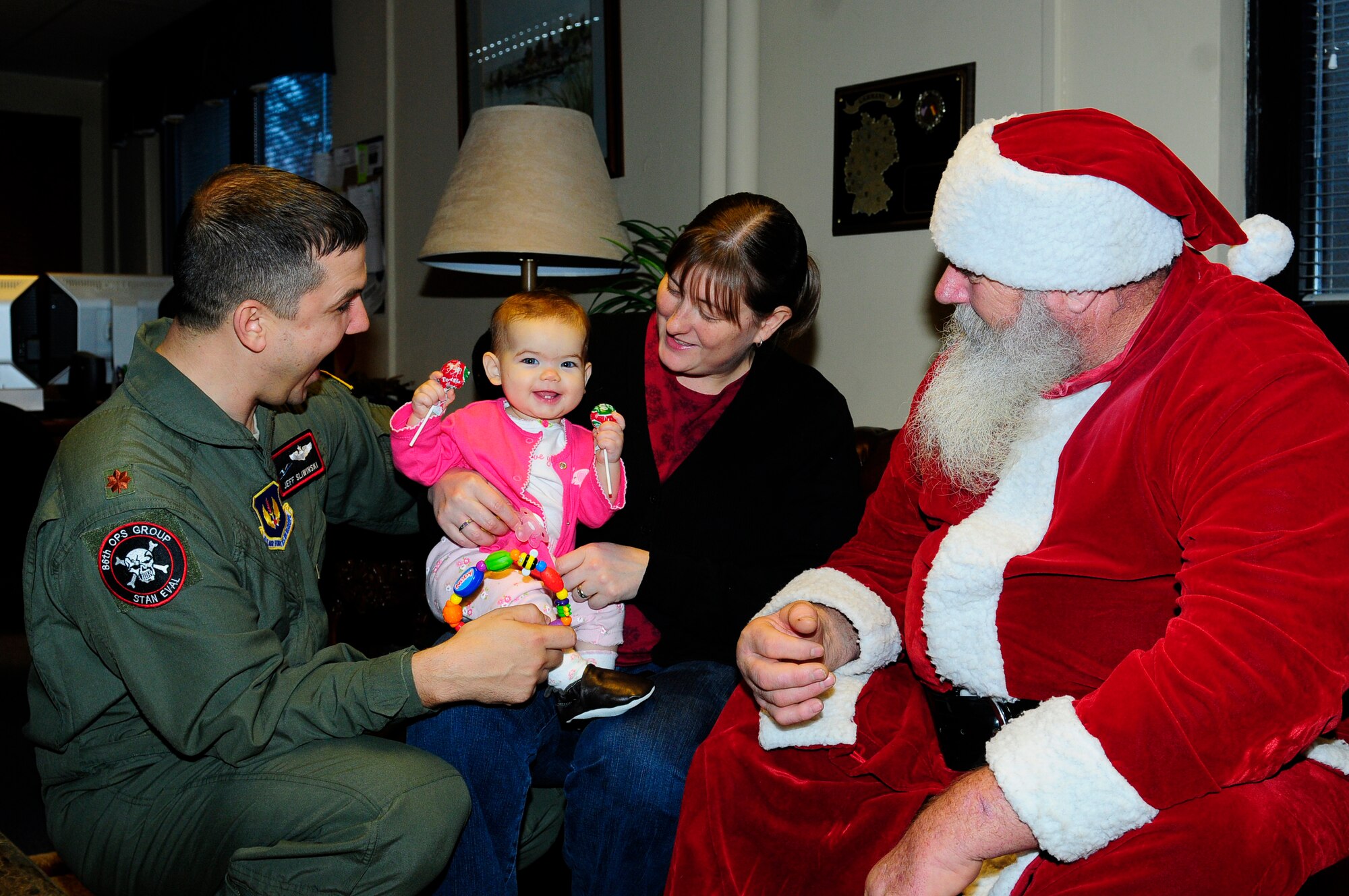 Air Force Maj. Jeff Sliwinski, 86th Operations Group, along with wife, Jessica, and daughter, Adela 8 mo., visit the Airman and Family Readiness Center to meet St. Nicholas, Ramstein Air Base, Germany, Dec. 6, 2011. St. Nicholas visited the A&FRC to meet with families and pass out candy to children. (U.S. Air Force Airman 1st Class Kendra Alba)