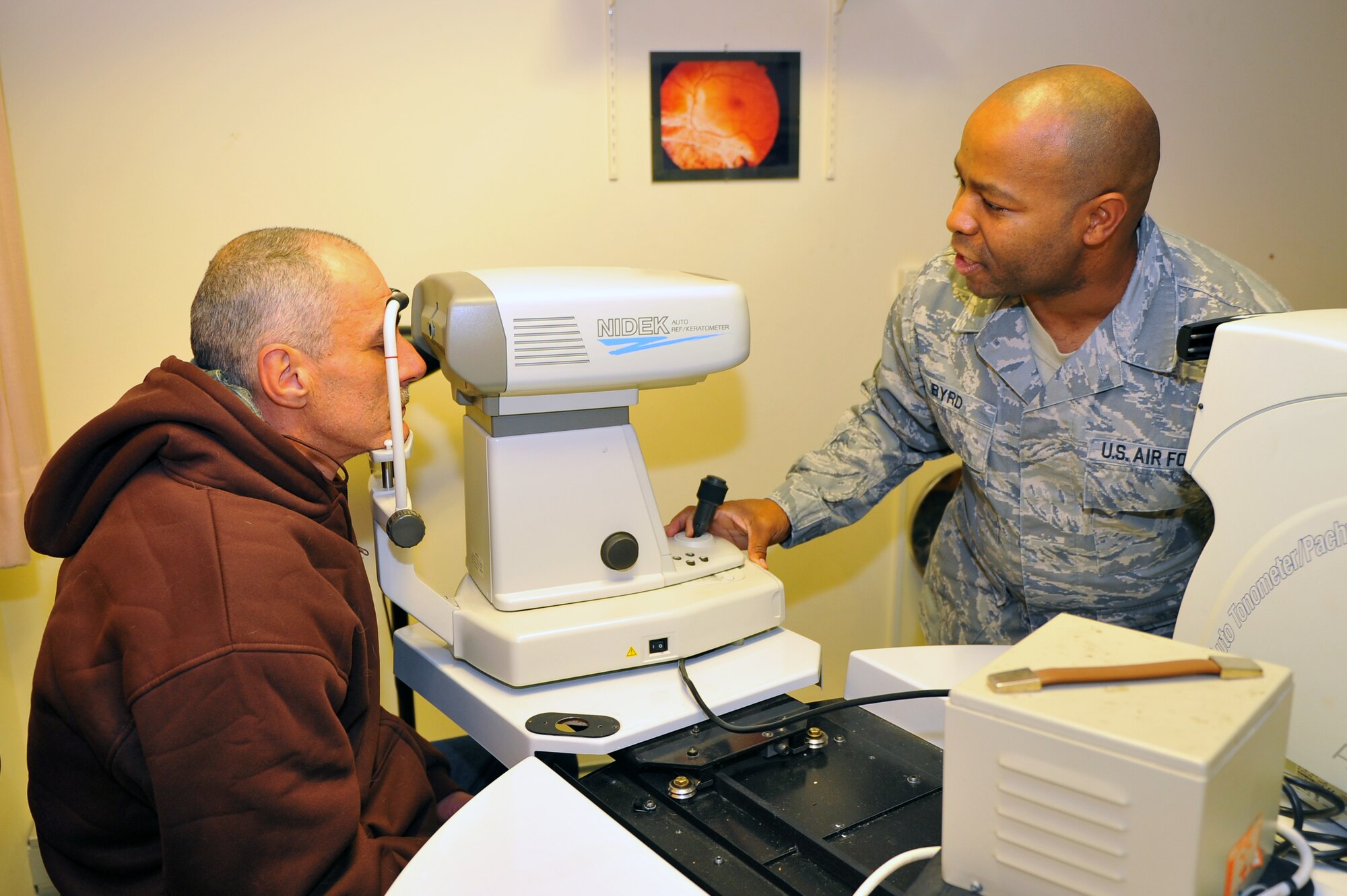 SPANGDAHLEM AIR BASE, Germany – Master Sgt. William Byrd, right, 52nd Aerospace Medicine Squadron ophthalmic  technician, administers a glaucoma test to Antonio Davis during an eye exam at the optometry clinic here Dec. 6. The AMDS provides vision correction as well as diagnosing, treating and managing ocular diseases to keep Airmen fit to fight and their family members healthy. (U.S. Air Force photo/Airman 1st Class Dillon Davis)