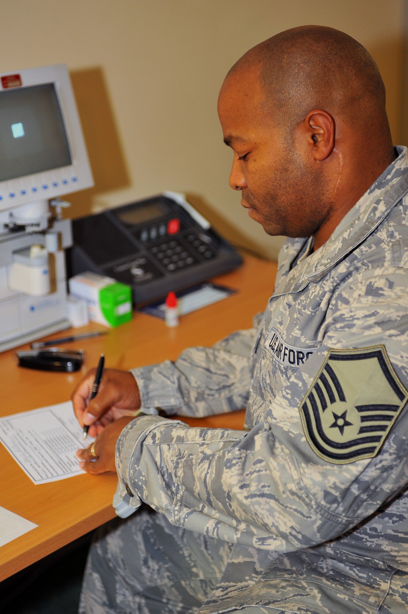 SPANGDAHLEM AIR BASE, Germany – Master Sgt. William Byrd, 52nd Aerospace Medicine Squadron ophthalmic  technician, fills out a patient vision checklist during an eye exam at the optometry clinic here Dec. 6. The AMDS provides vision correction as well as diagnosing, treating and managing ocular diseases to keep Airmen fit to fight and their family members healthy. (U.S. Air Force photo/Airman 1st Class Dillon Davis)
