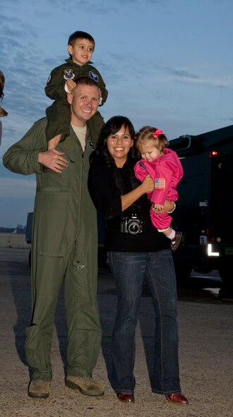 Maj. Chris Occhiuzzo, 20th Bomb Squadron, poses with his wife Olivia, and children Miles, 2, and Courtney, 11 months, on Barksdale Air Force Base, La., Dec. 2 upon his return from a deployment to Guam. The 20 BS deployed in support of the continuous bomber presence in the Pacific region. (U.S. Air Force photo/Airman 1st Class Benjamin Gonsier)(RELEASED)