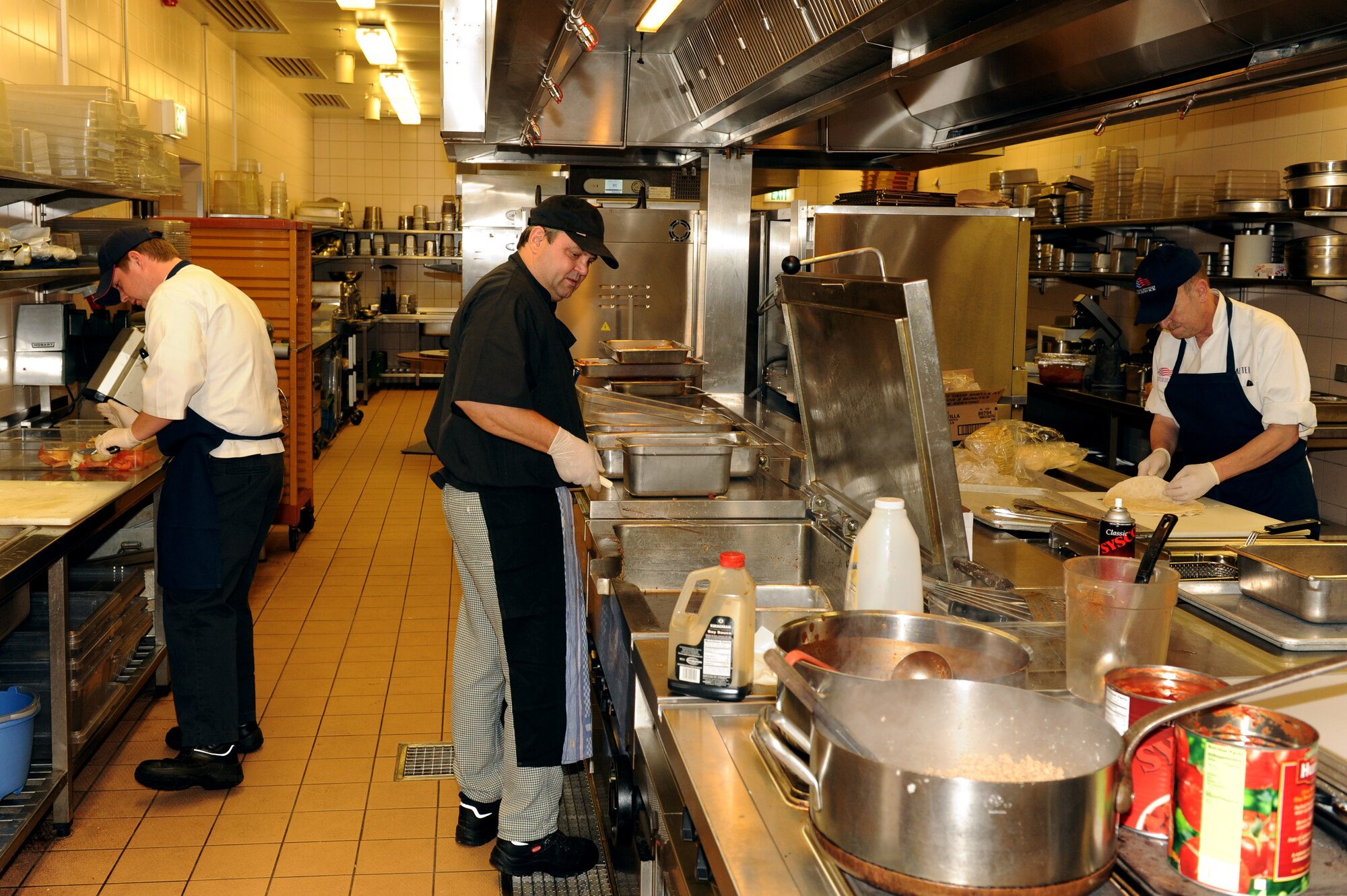 SPANGDAHLEM AIR BASE, Germany – Dennies Tautges, left, Heinz Toeller, center, and Walter Vrzal, 52nd Force Support Squadron cooks, prepare lunch at Club Eifel here Dec. 1. Club Eifel Catering offers buffets and hors d’oeuvres style meals for pick-up or delivery and a catering staff upon request. For more information, call DSN 452-4642 or 06565-61-4642. (U.S. Air Force photo/Airman 1st Class Matthew B. Fredericks)