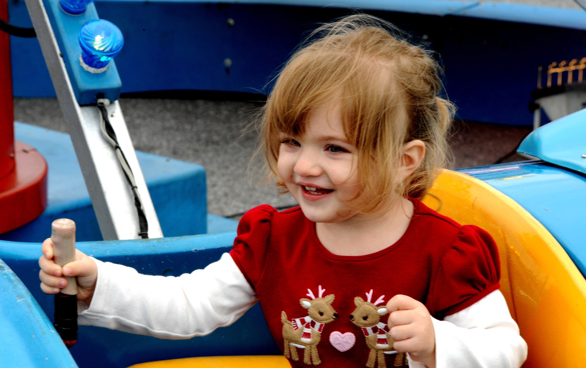 Riley Elleman enjoys the airplane ride at the Schilling Community Center during the 2011 Tinsel Town, Dec. 2, on Kadena Air Base, Japan. Tinsel Town included many attractions for children including bouncers, a merry-go-round, train rides, and a chance for kids to meet Santa Claus. (U.S. Air Force photo by Airman 1st Class Justin Veazie/Released)