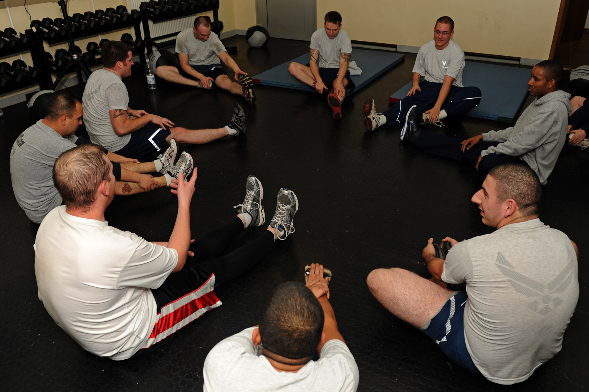 SPANGDAHLEM AIR BASE, Germany – Members of the 52nd Maintenance Group stretch at the end of fitness training at the combat fitness facility here Nov. 30. Air Force Fitness Assessments continue throughout the winter season; however, the 1.5 mile run portion will consist of 22 laps inside the Skelton Memorial Fitness Center gymnasium on days when the temperature falls below 20 degrees Fahrenheit. (U.S. Air Force photo/Airman 1st Class Matthew B. Fredericks)