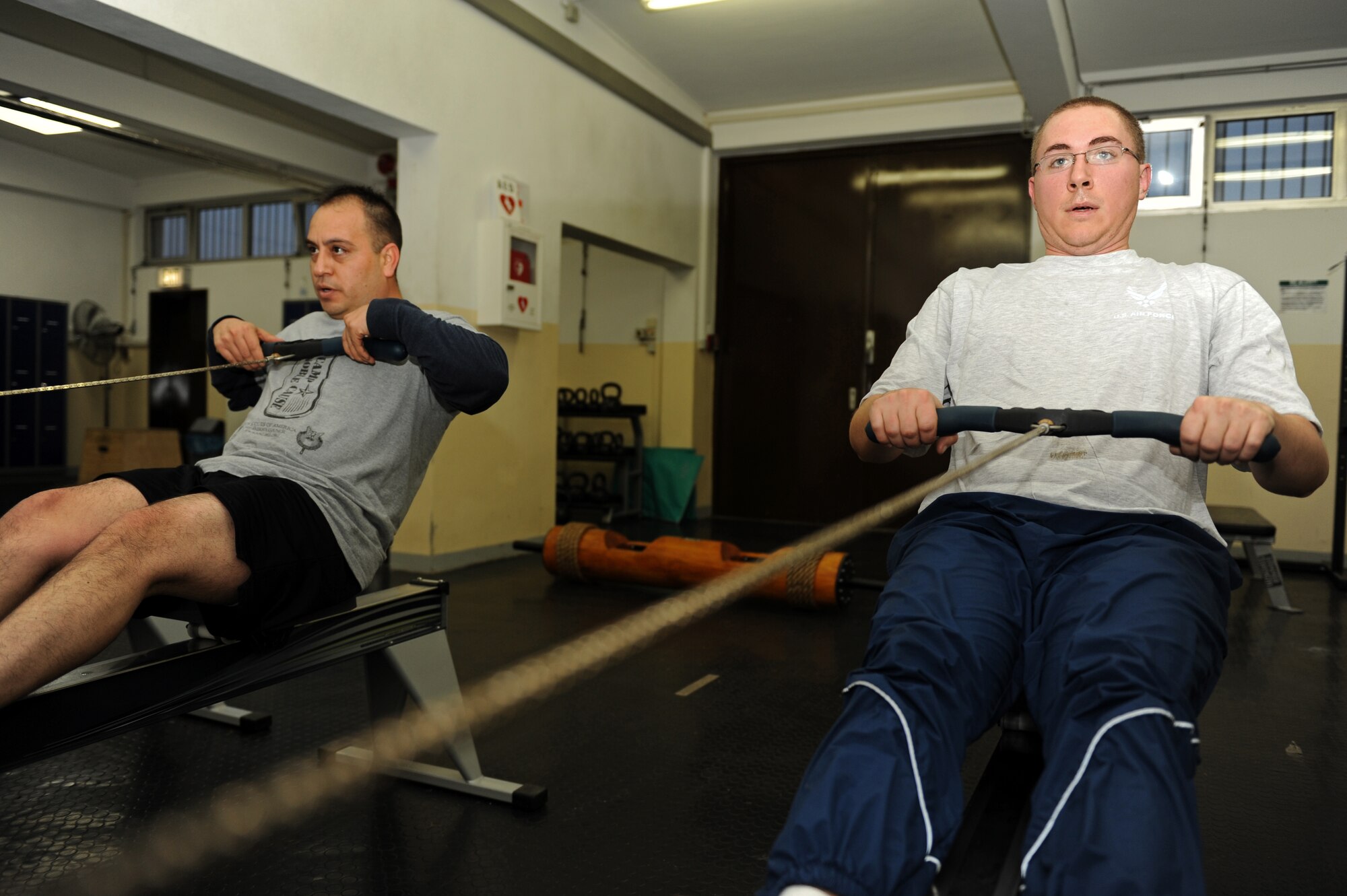 SPANGDAHLEM AIR BASE, Germany – Staff Sgt. David Gomez, left, 52nd Component Maintenance Squadron unit education and training manager, and Senior Airman Justin Blakeman, 52nd CMS aircraft fuels systems repair journeyman, use rowing machines during fitness training at the combat fitness facility here Nov. 30. Air Force Fitness Assessments continue throughout the winter season; however, the 1.5 mile run portion will consist of 22 laps inside the Skelton Memorial Fitness Center gymnasium on days when the temperature falls below 20 degrees Fahrenheit. (U.S. Air Force photo/Airman 1st Class Matthew B. Fredericks)